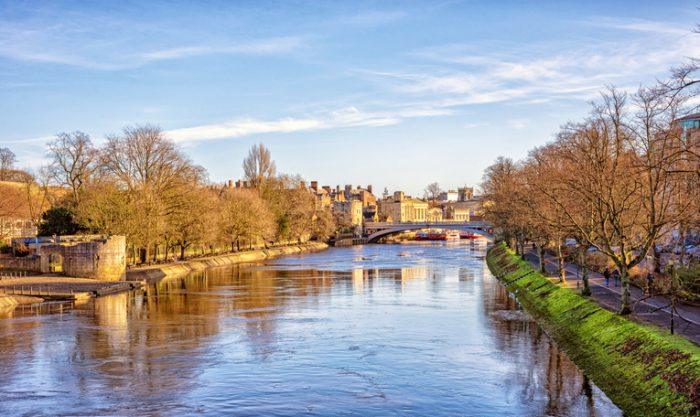 A scenic view of the river Ouse in York against a blue sky