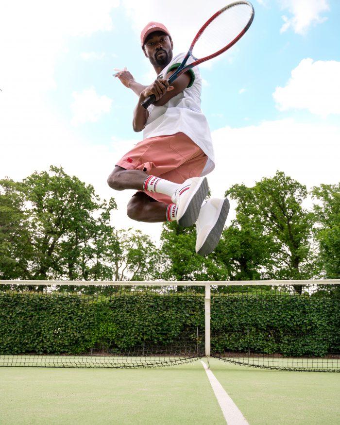 Man jumping high up on the tennis court, holding his racquet 
