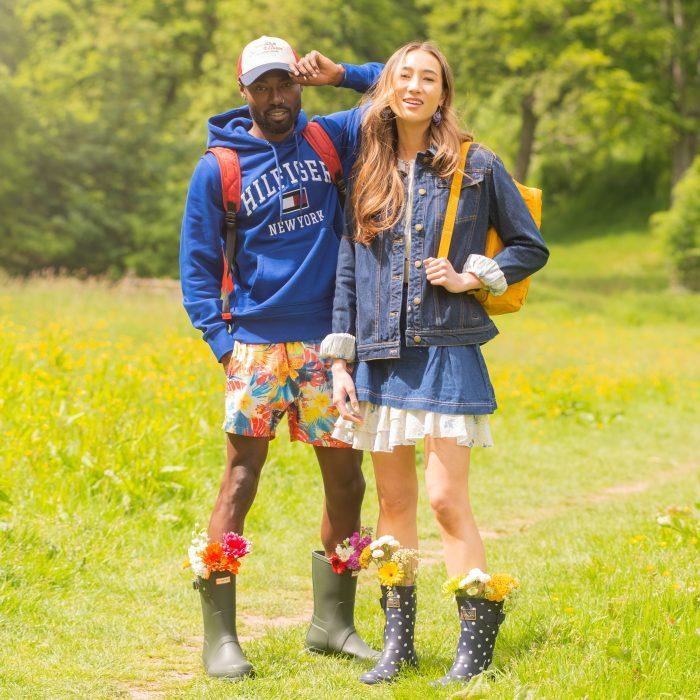 Man and woman stand in a field dressed for a festival