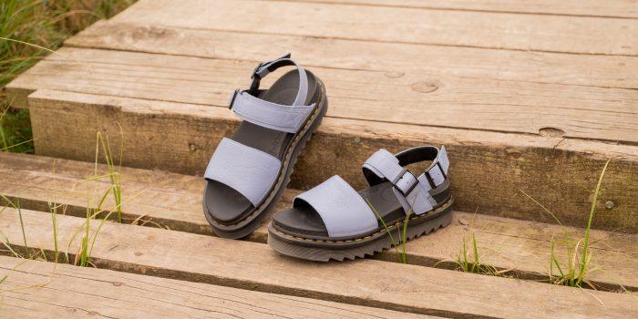 A close up of some pastel coloured Dr Martens sandals on some decking