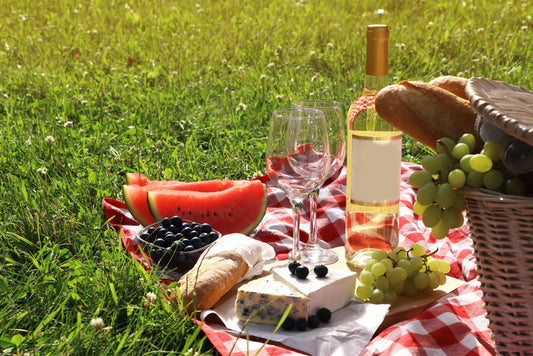 A picnic blanket with fruit and wine