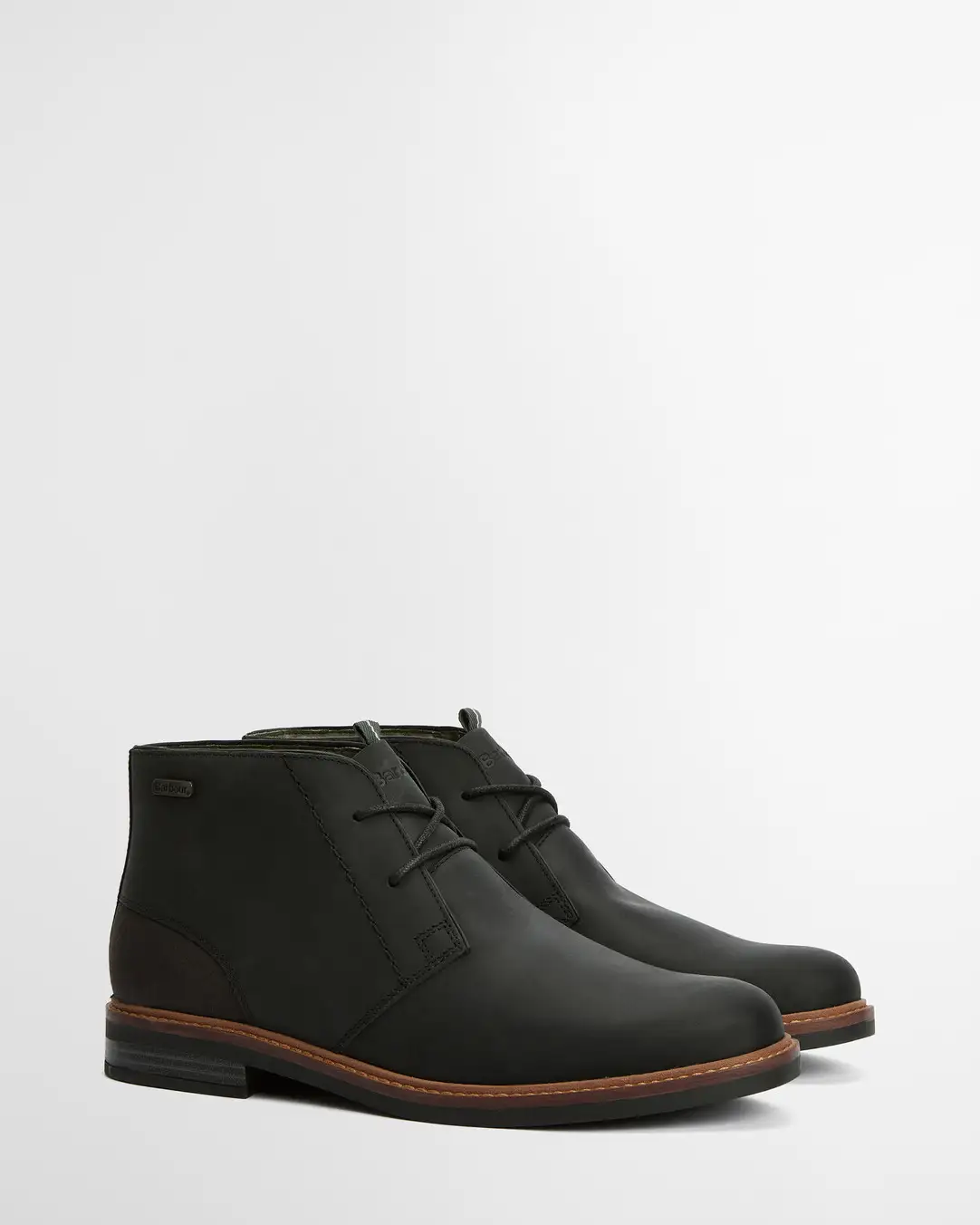 Pair of black leather boots on a light gray background