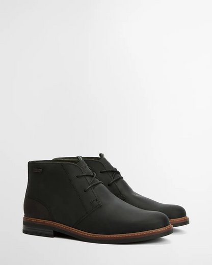 Pair of black leather boots on a light gray background