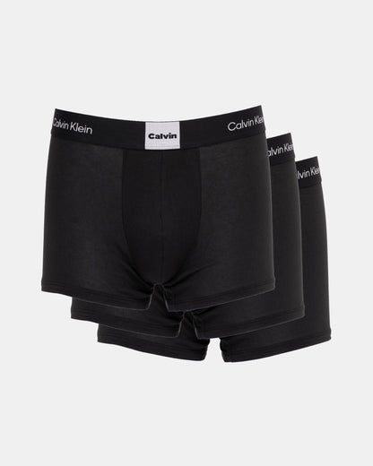 Three black Calvin Klein boxer briefs on a white background