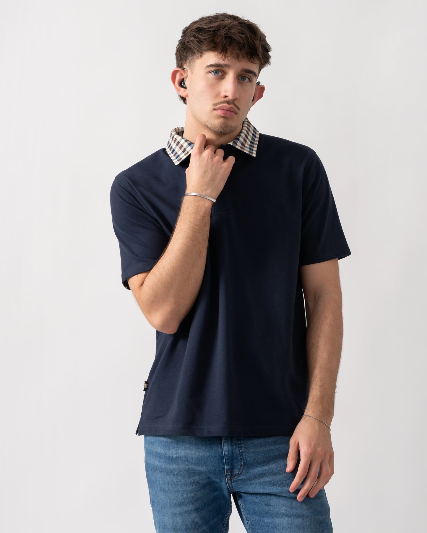 Studio shot of a model wearing an Aquascutum Mens Club Check Collar Polo Shirt in Navy 11