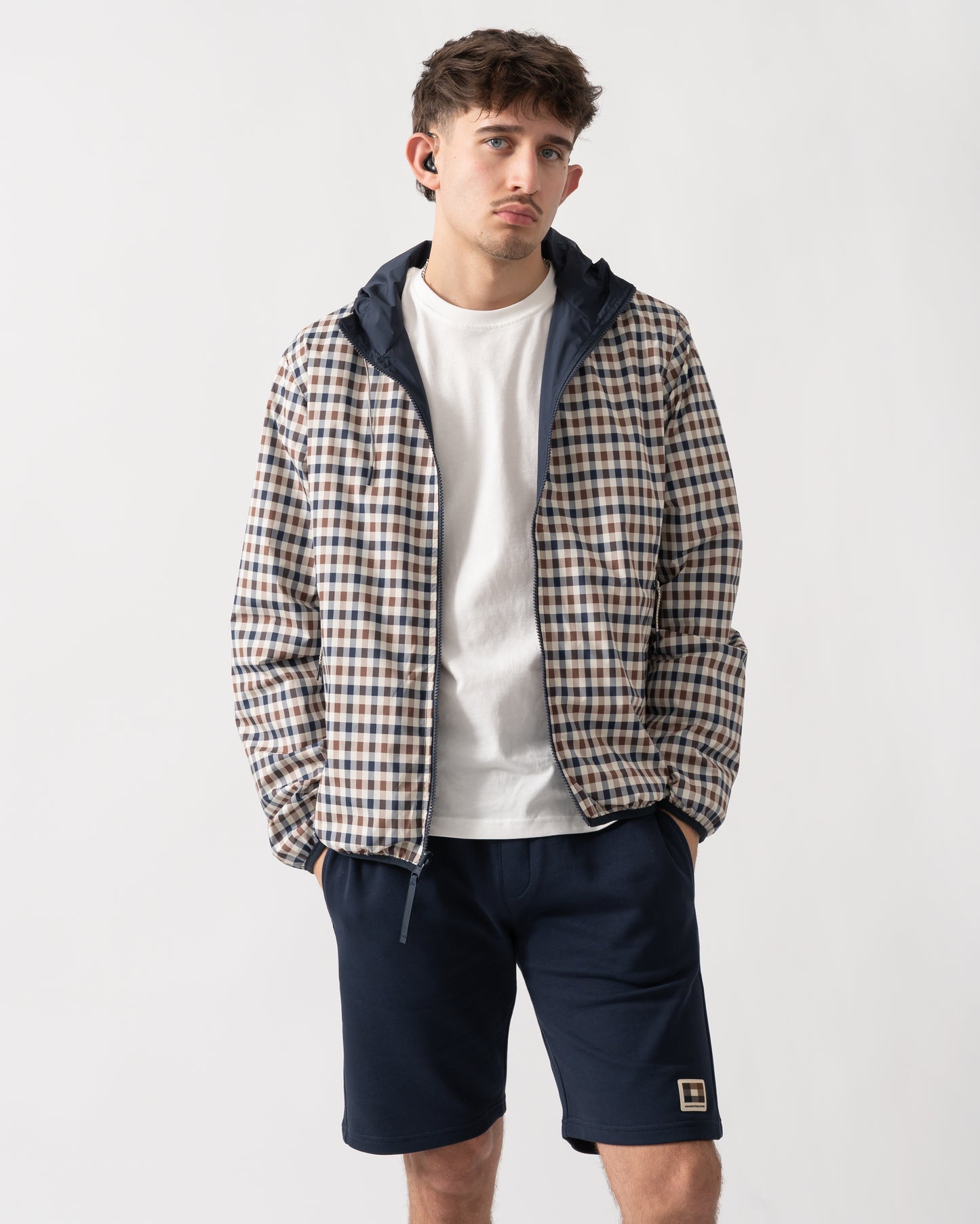 studio shot of a model wearing an Aquascutum Mens RLG Badge Reversible Sailor Jacket in Navy, showing reversed check pattern