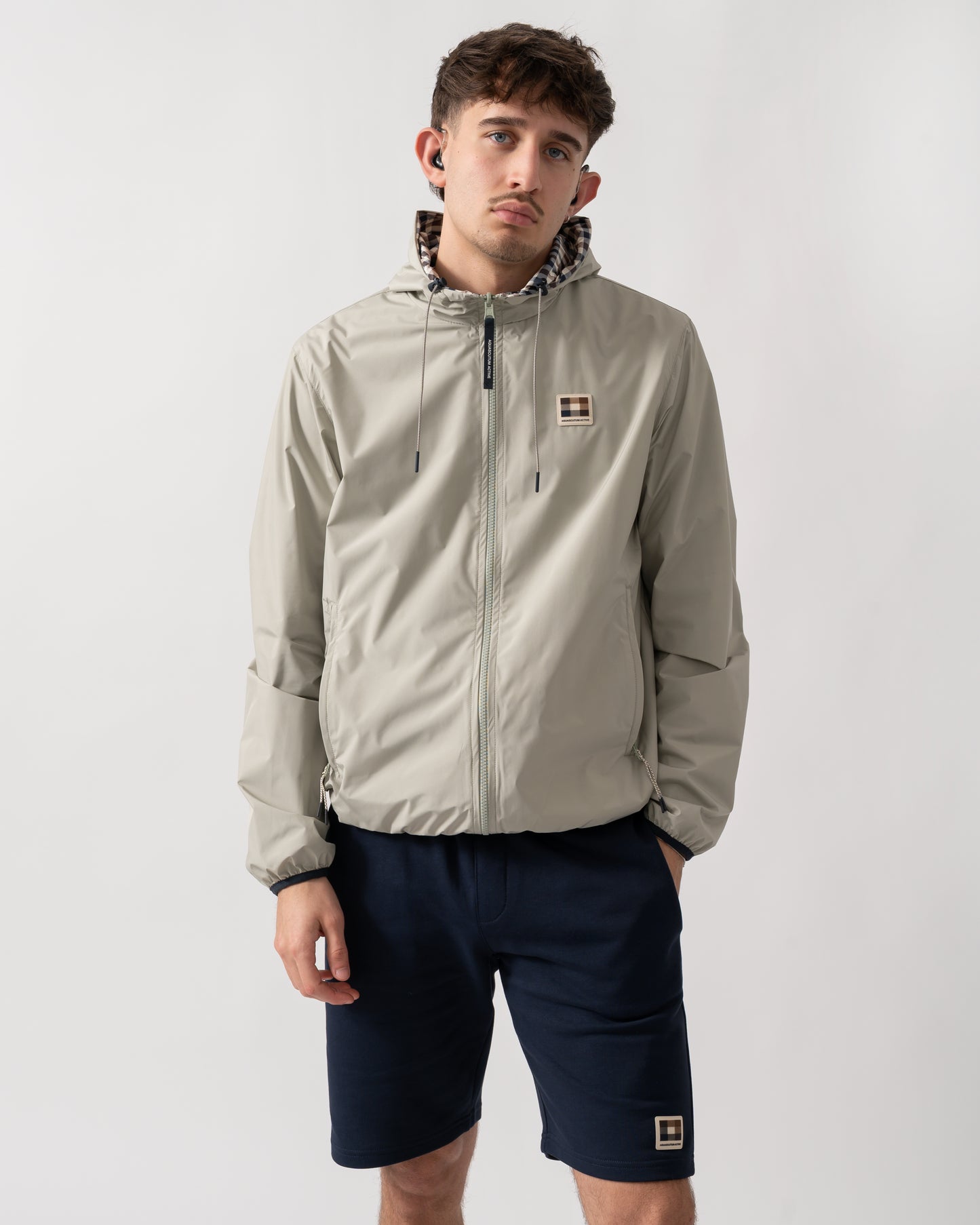 studio shot of a model wearing an Aquascutum Mens RLG Badge Reversible Sailor Jacket in Salvia 34
