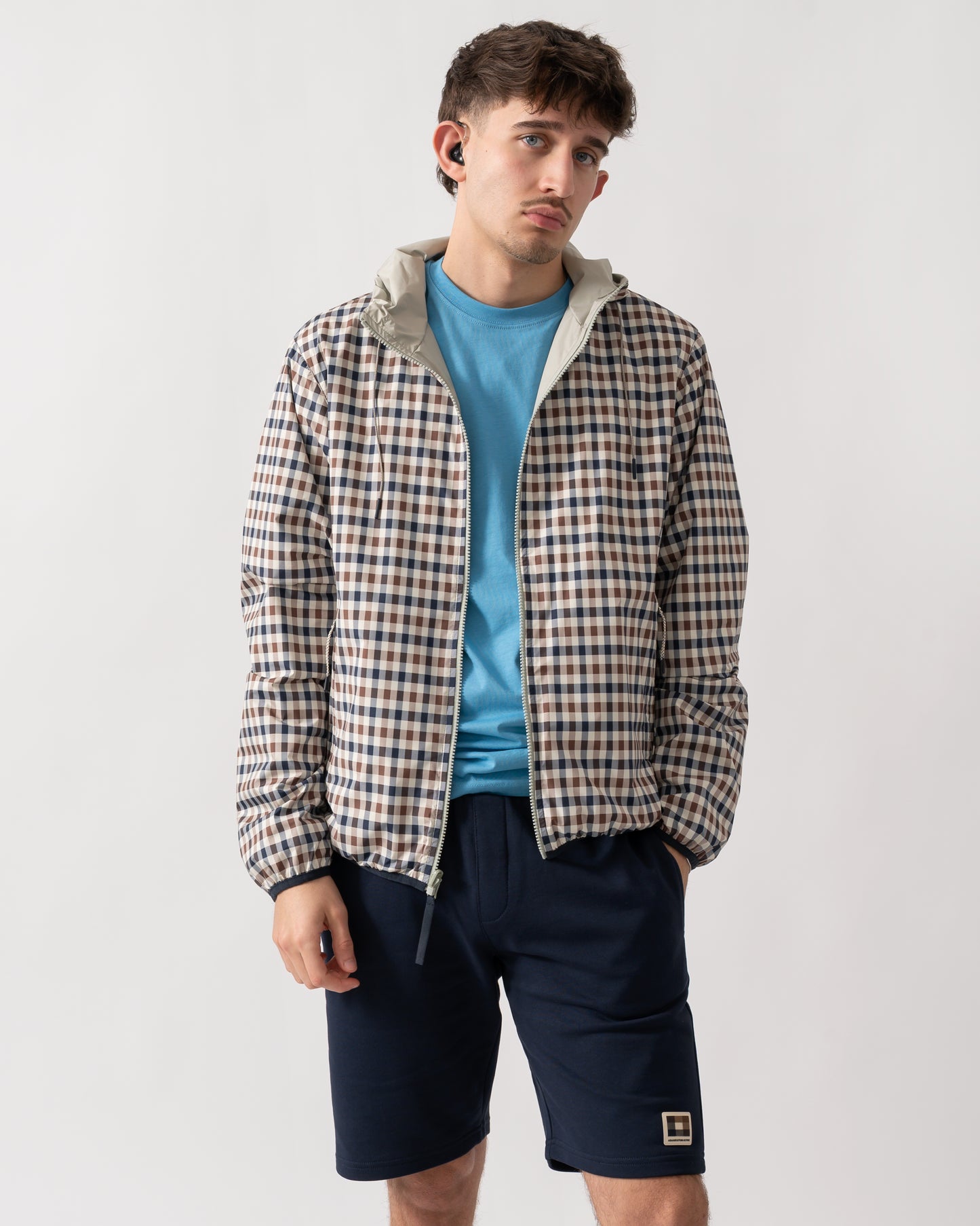 mid shot of a model wearing an Aquascutum Mens RLG Badge Reversible Sailor Jacket in Salvia 34 showing reversed check pattern