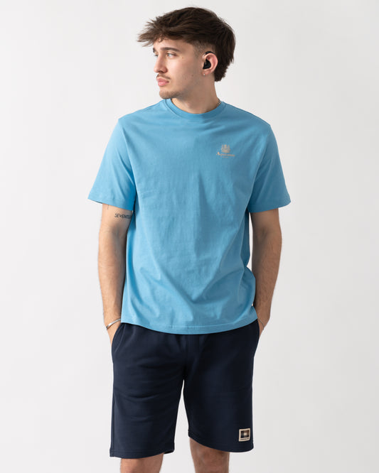 studio shot of a model wearing an Aquascutum Mens Small Logo T-Shirt in Avio 18