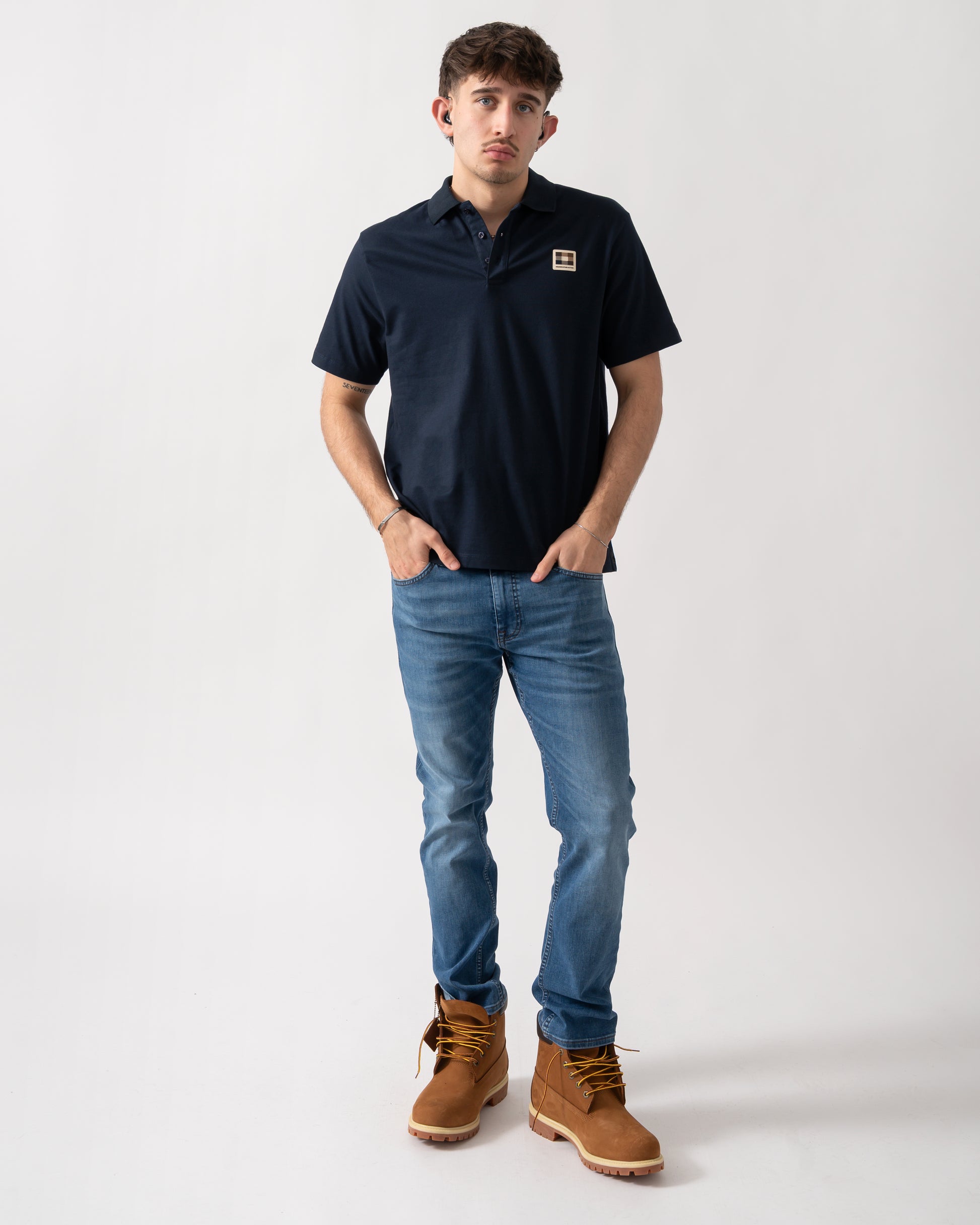 full length shot of a model wearing an Aquascutum Mens Stretch Piquet Badge Polo Shirt in Navy 11