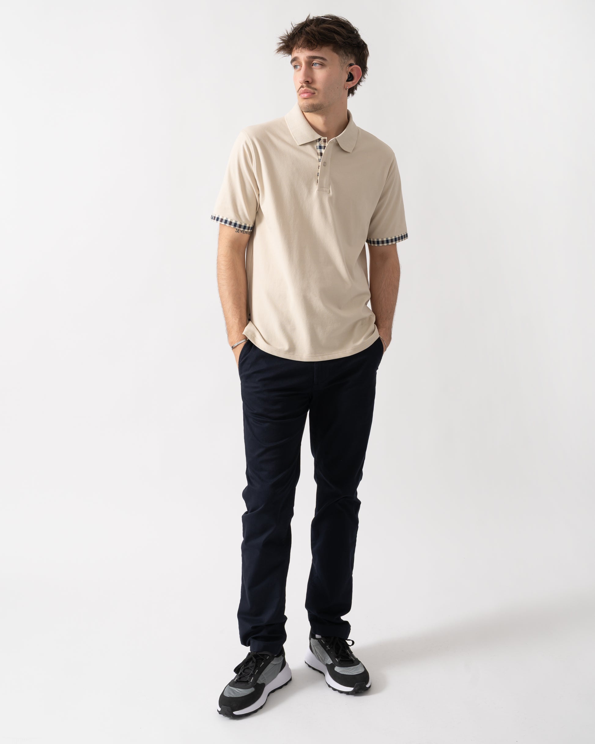 full length shot of a model wearing an Aquascutum Mens Club Check Stretch Piquet Sleeves Polo Shirt in Beige 03