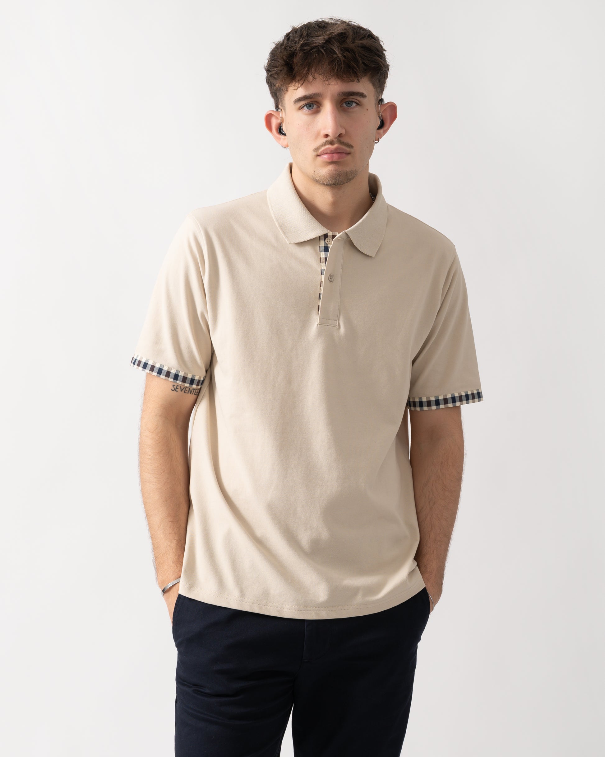 studio shot of a model wearing an Aquascutum Mens Club Check Stretch Piquet Sleeves Polo Shirt in Beige 03