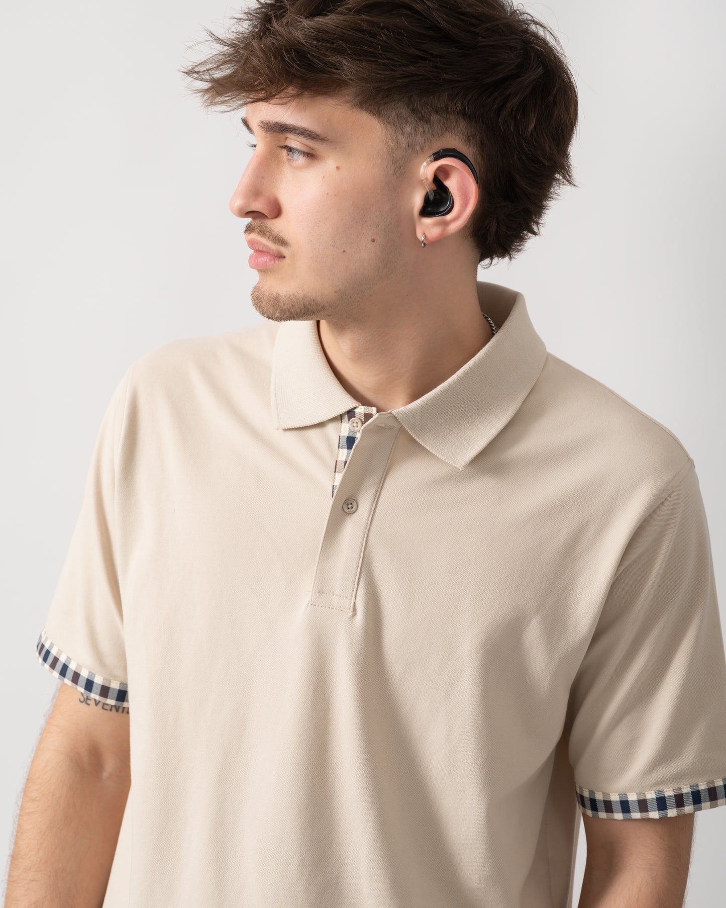 close up shot of a model wearing an Aquascutum Mens Club Check Stretch Piquet Sleeves Polo Shirt in Beige 03
