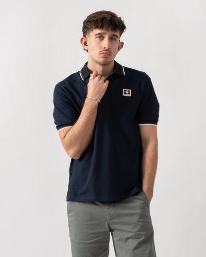 studio shot of a model wearing an Aquascutum Mens Stretch Piquet Tipped Badge Polo Shirt in Navy 11