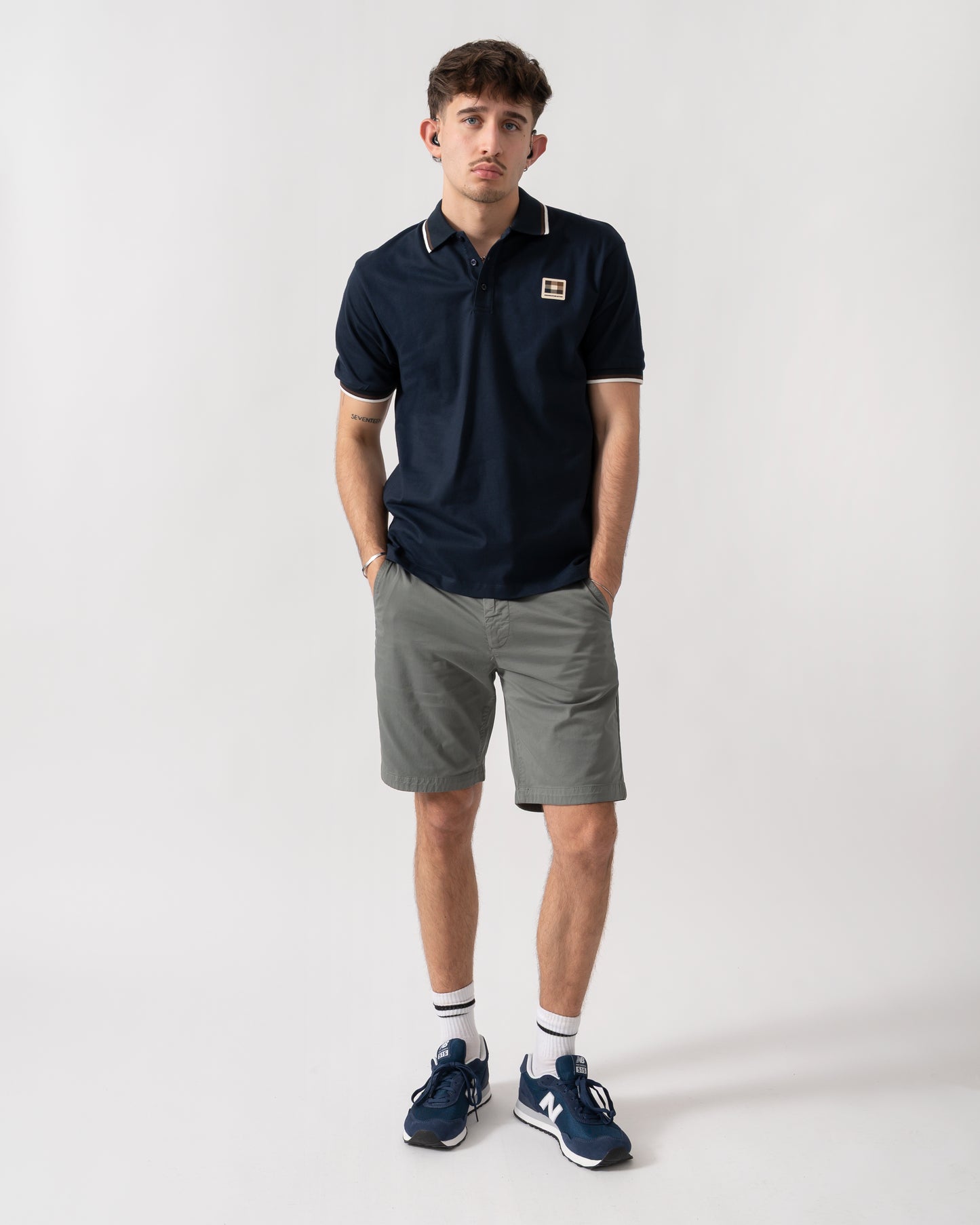 full length shot of a model wearing an Aquascutum Mens Stretch Piquet Tipped Badge Polo Shirt in Navy 11