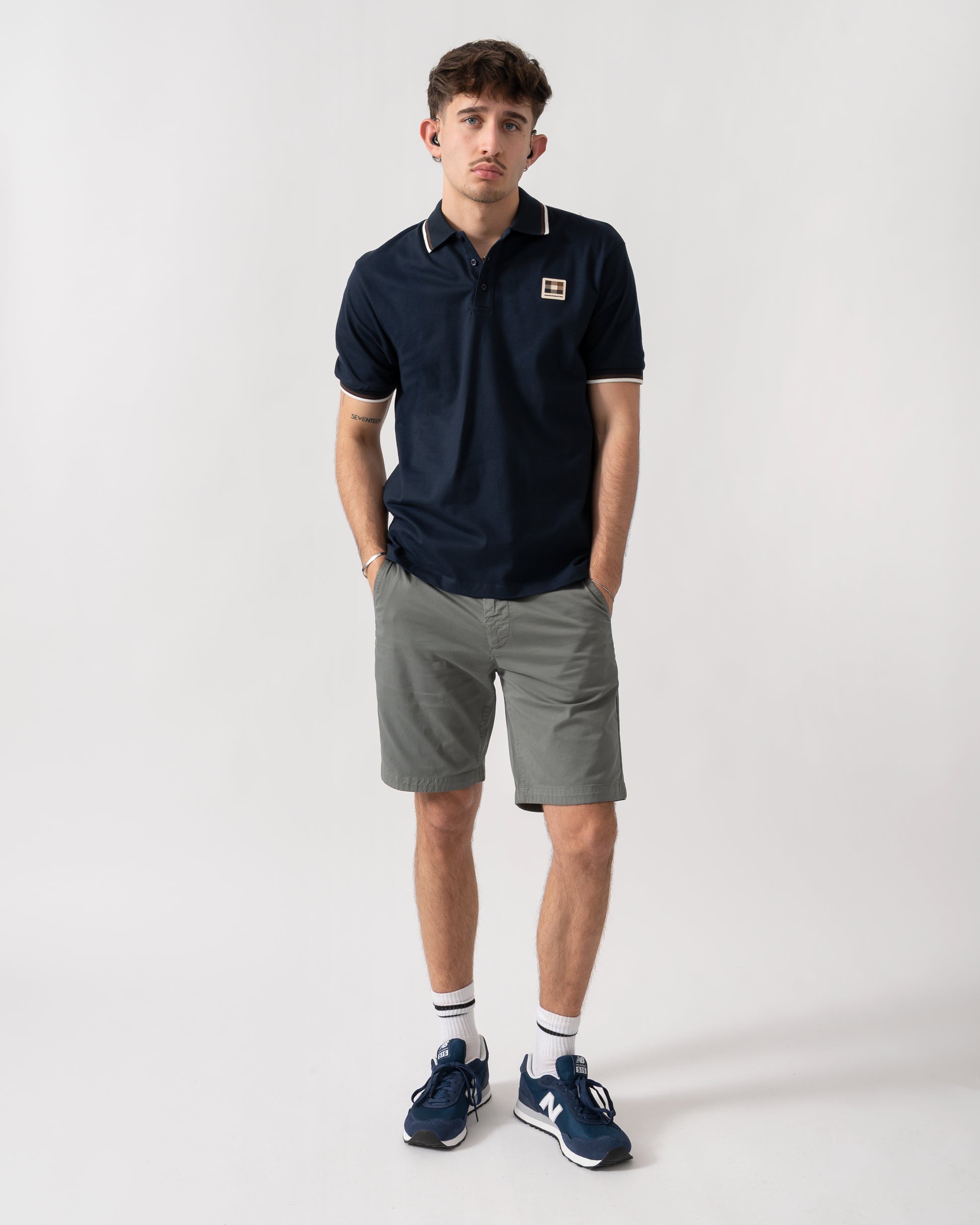 full length shot of a model wearing an Aquascutum Mens Stretch Piquet Tipped Badge Polo Shirt in Navy 11