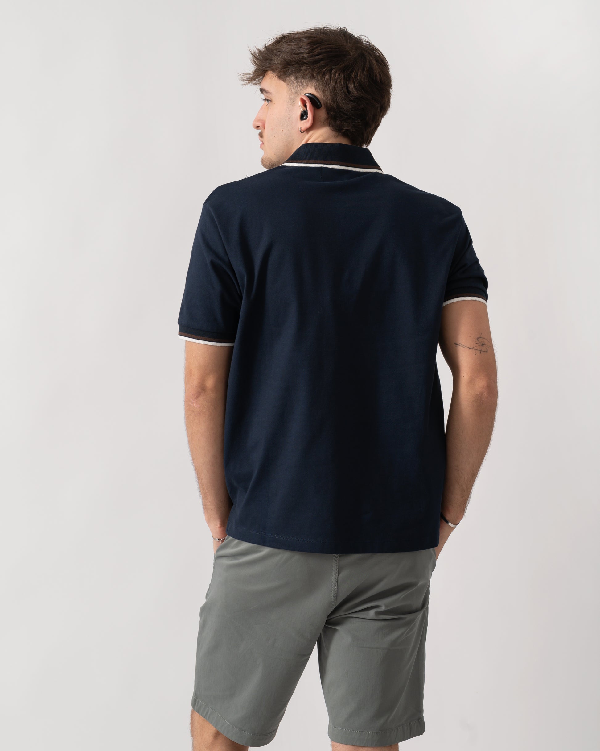 back shot of a model wearing an Aquascutum Mens Stretch Piquet Tipped Badge Polo Shirt in Navy 11