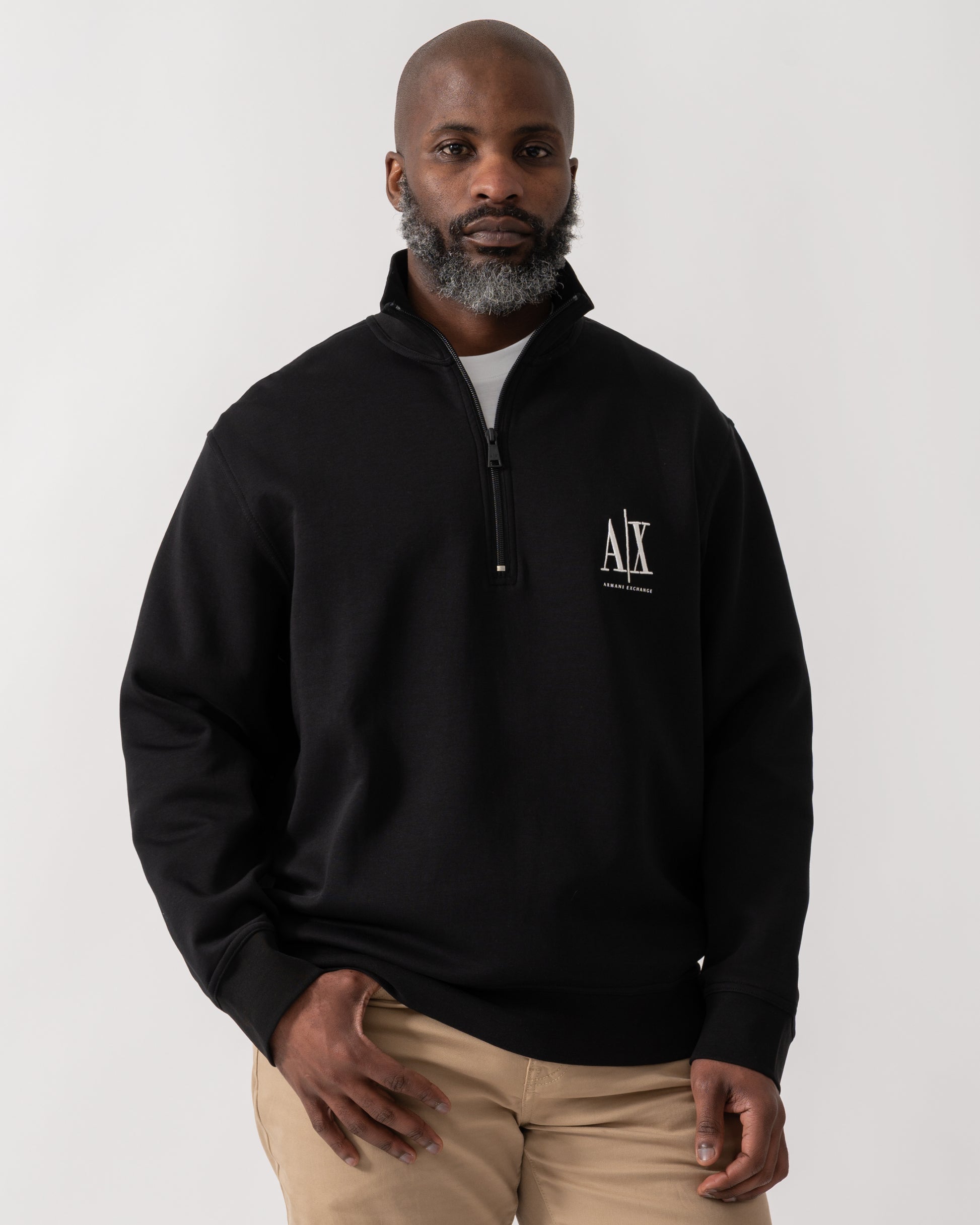 model wearing an Armani Exchange Mens Embroidered A|X Logo 1/4 Zip Sweatshirt in Black