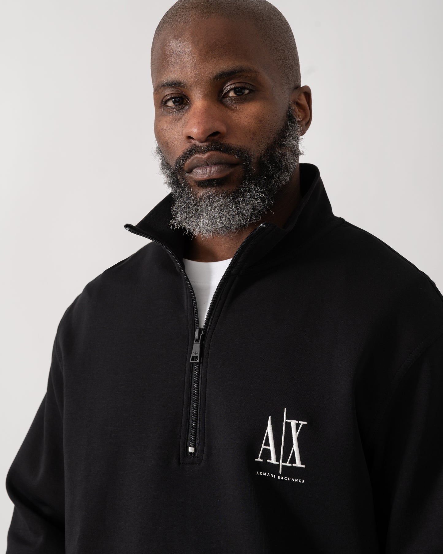 detail shot of a model wearing an Armani Exchange Mens Embroidered A|X Logo 1/4 Zip Sweatshirt in Black