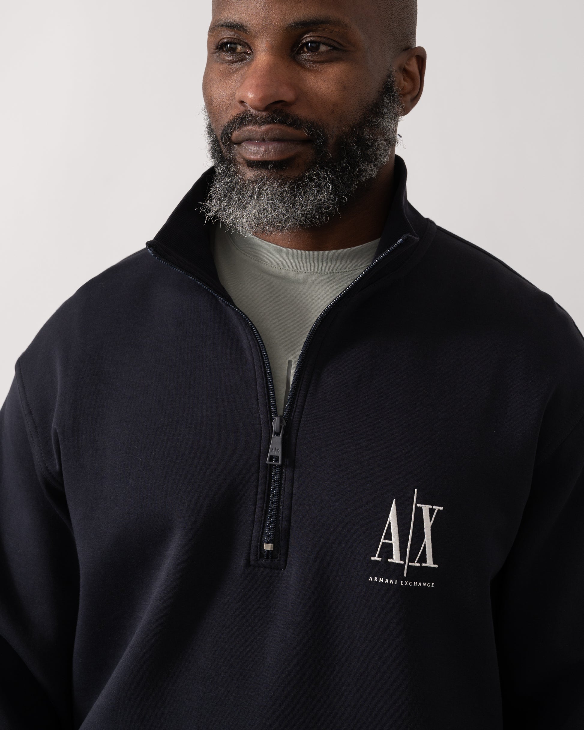 Close up shot of a Model wearing an Armani Exchange Mens Embroidered A|X Logo 1/4 Zip Sweatshirt in Deep Navy