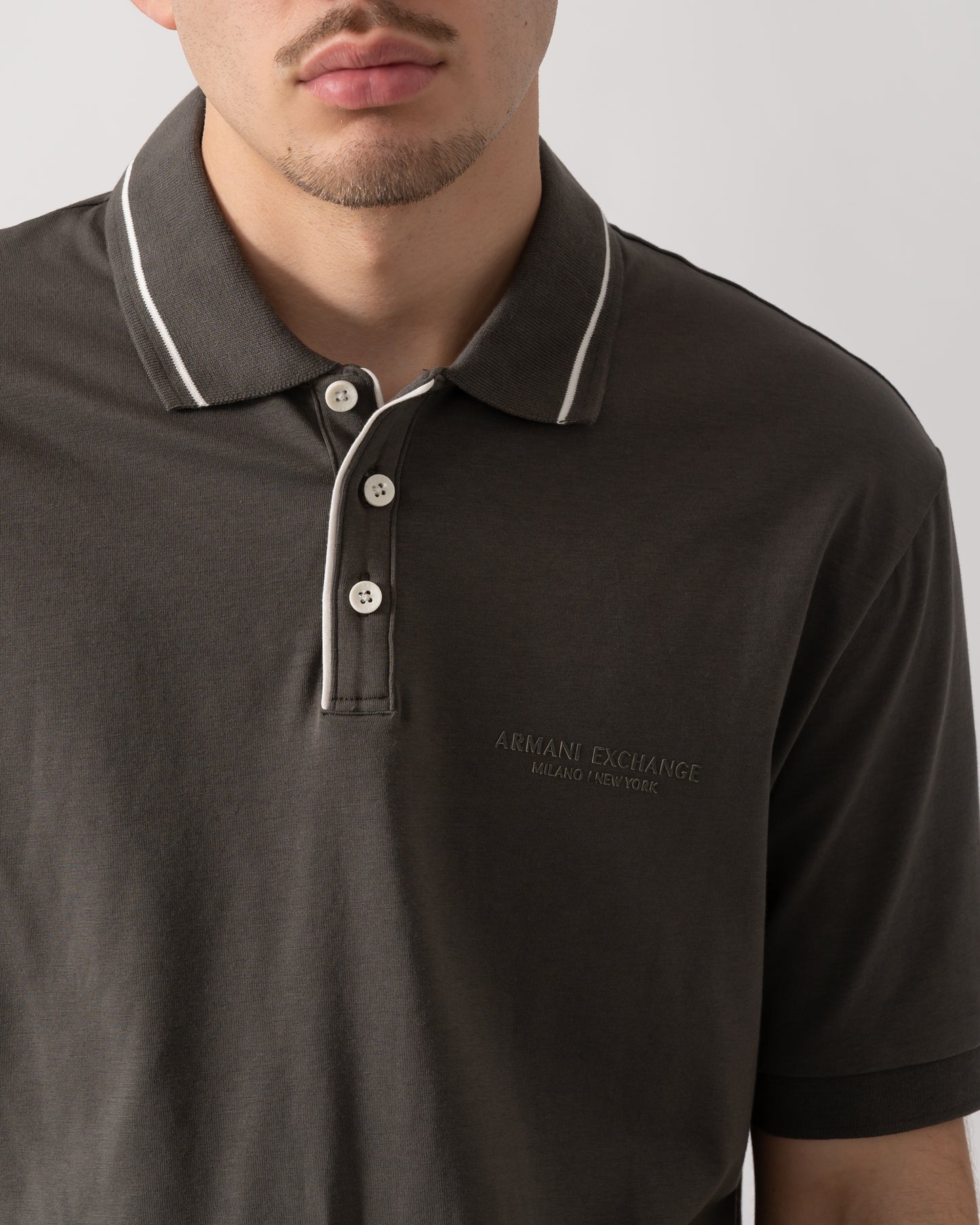 close up shot of a model wearing an Armani Exchange Mens Milano/New York Polo Shirt with Contrast Tipping in Chimera M8317