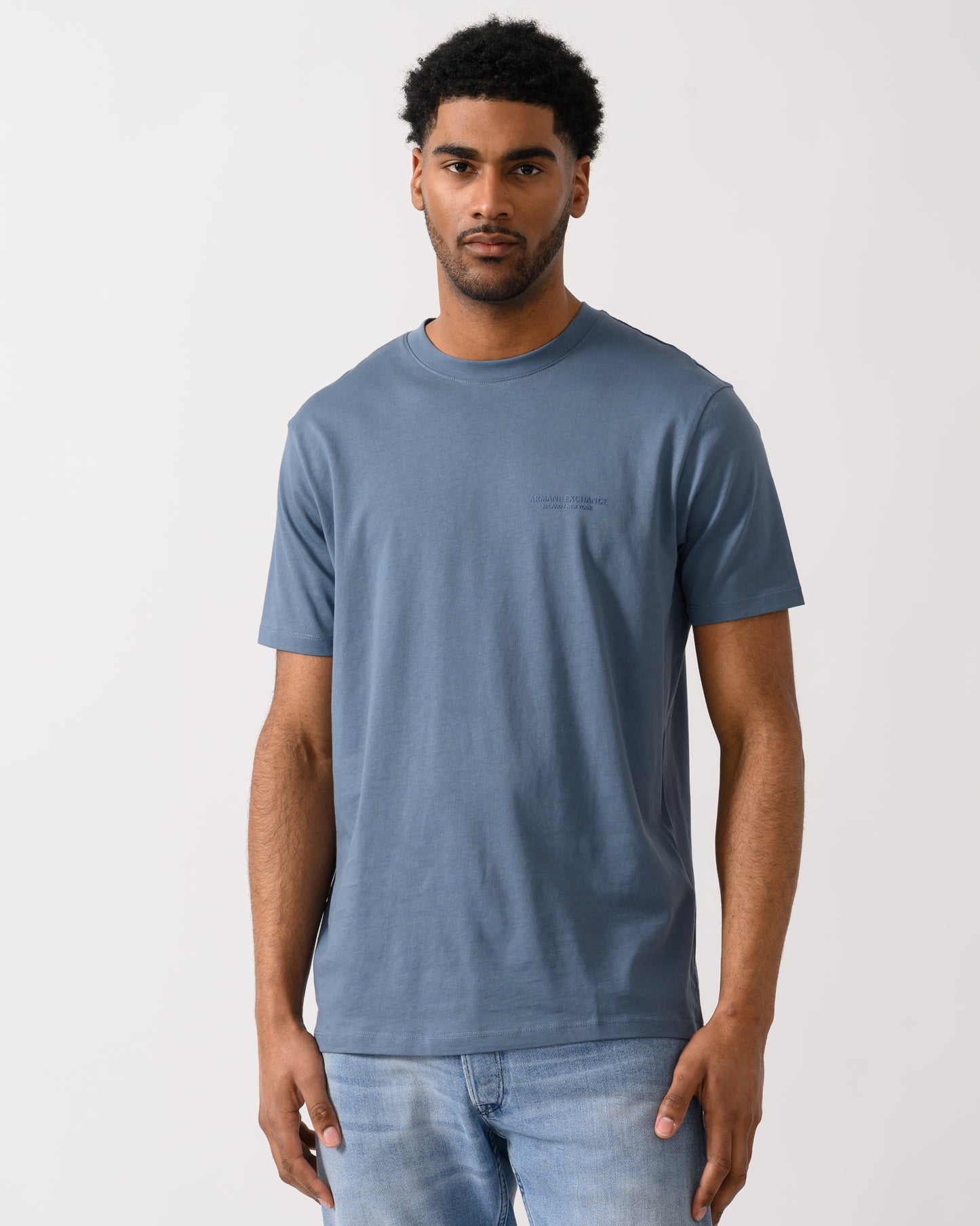 model wearing a Armani Exchange Mens T-Shirt with Small Milano-New York Logo in China Blue