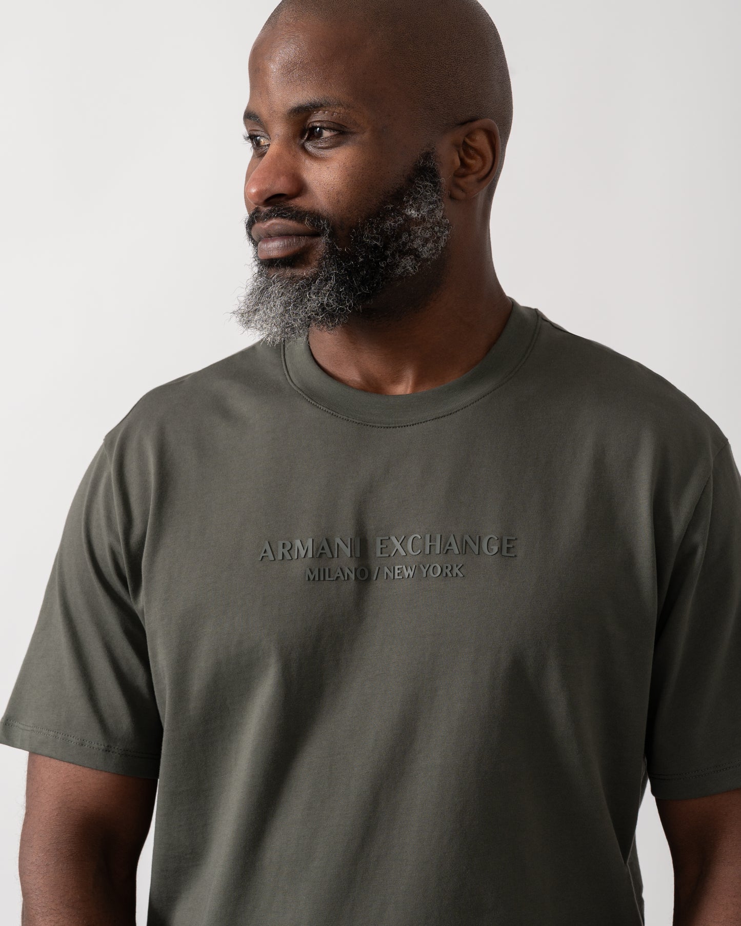 Close up shot of a Model wearing an Armani Exchange Mens T-Shirt with Tonal Milano/New York Logo in Chimera