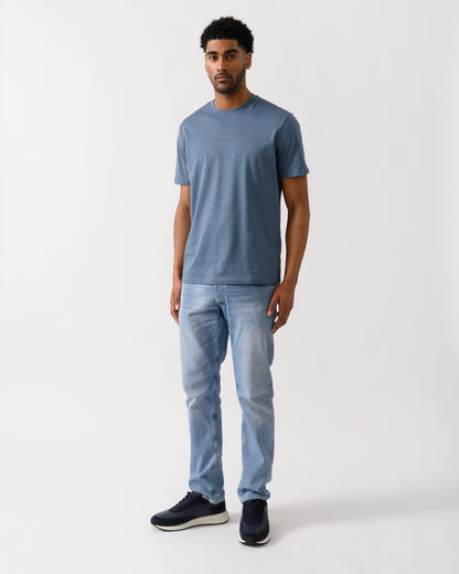 full length view of a Model wearing an Armani Exchange Mens T-Shirt with Tonal Milano/New York Logo in China Blue U9302