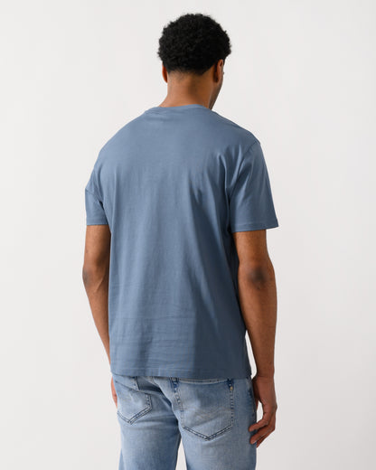 rear view of a Model wearing an Armani Exchange Mens T-Shirt with Tonal Milano/New York Logo in China Blue U9302