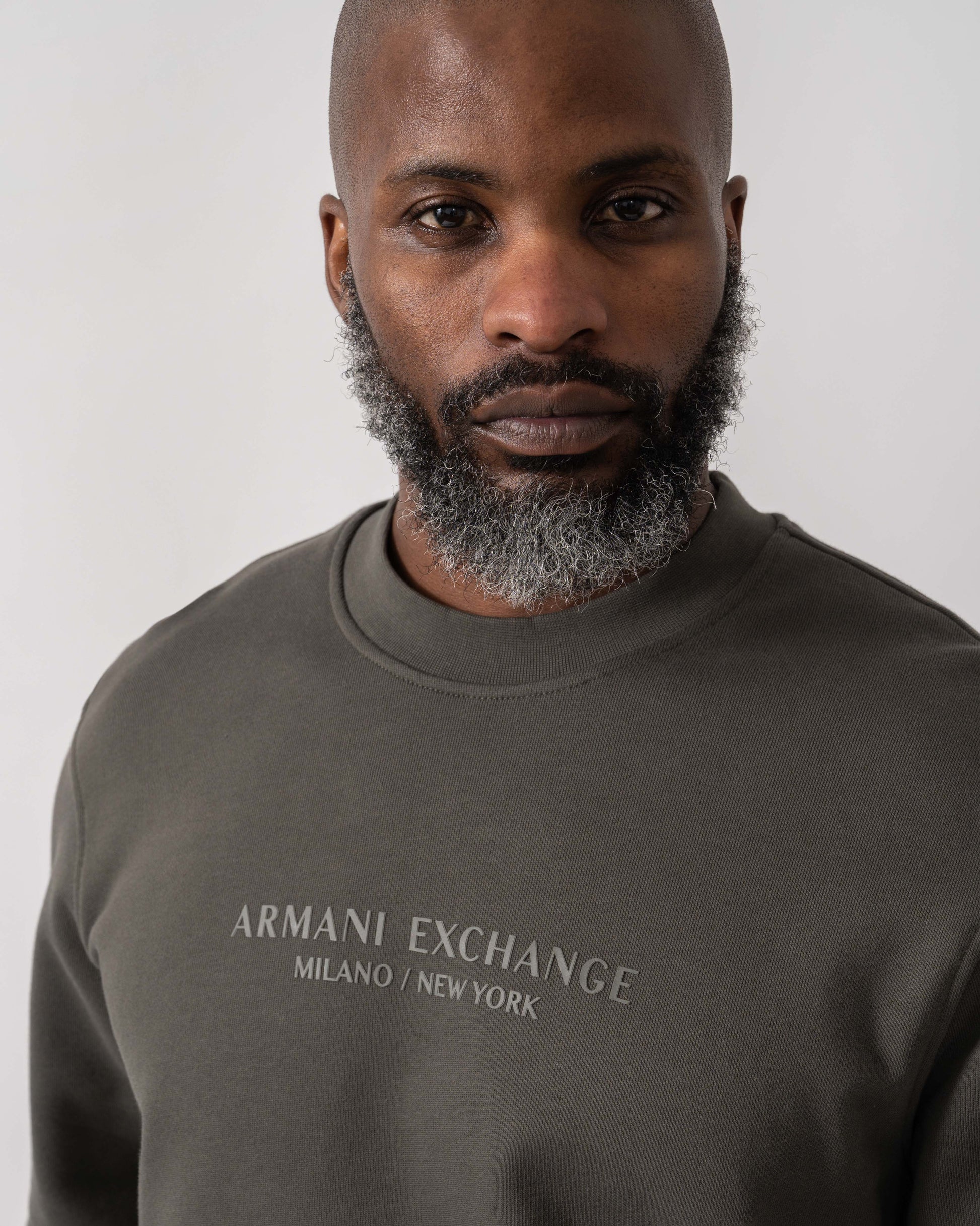 Model wearing Armani Exchange Mens Crew Neck Sweatshirt with Tonal Milano/New York Logo in Chimera M8317 - Logo detail