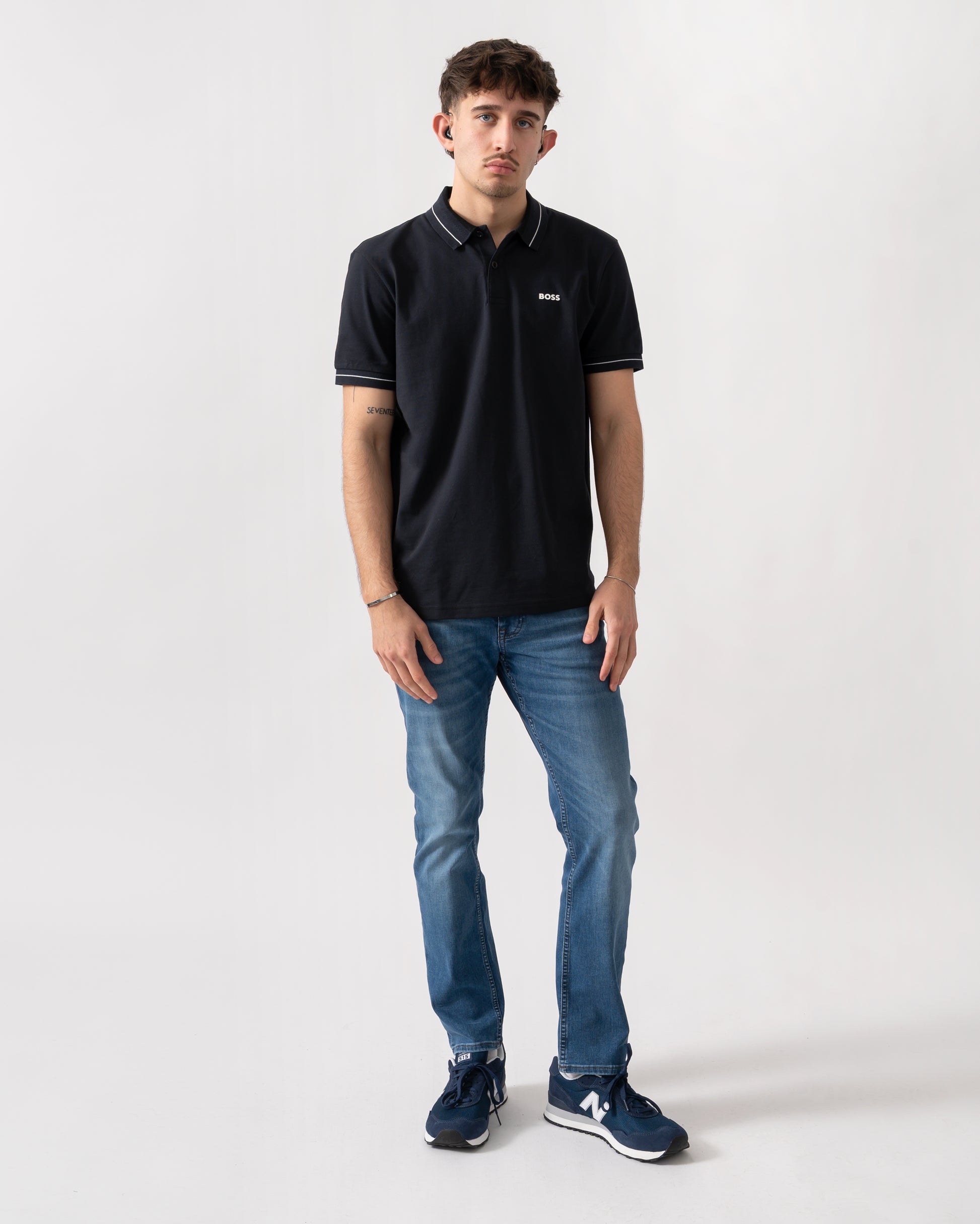 full length shot of a model wearing a BOSS Green PL_Member Mens Short Sleeve Polo Shirt in Dark Blue 402