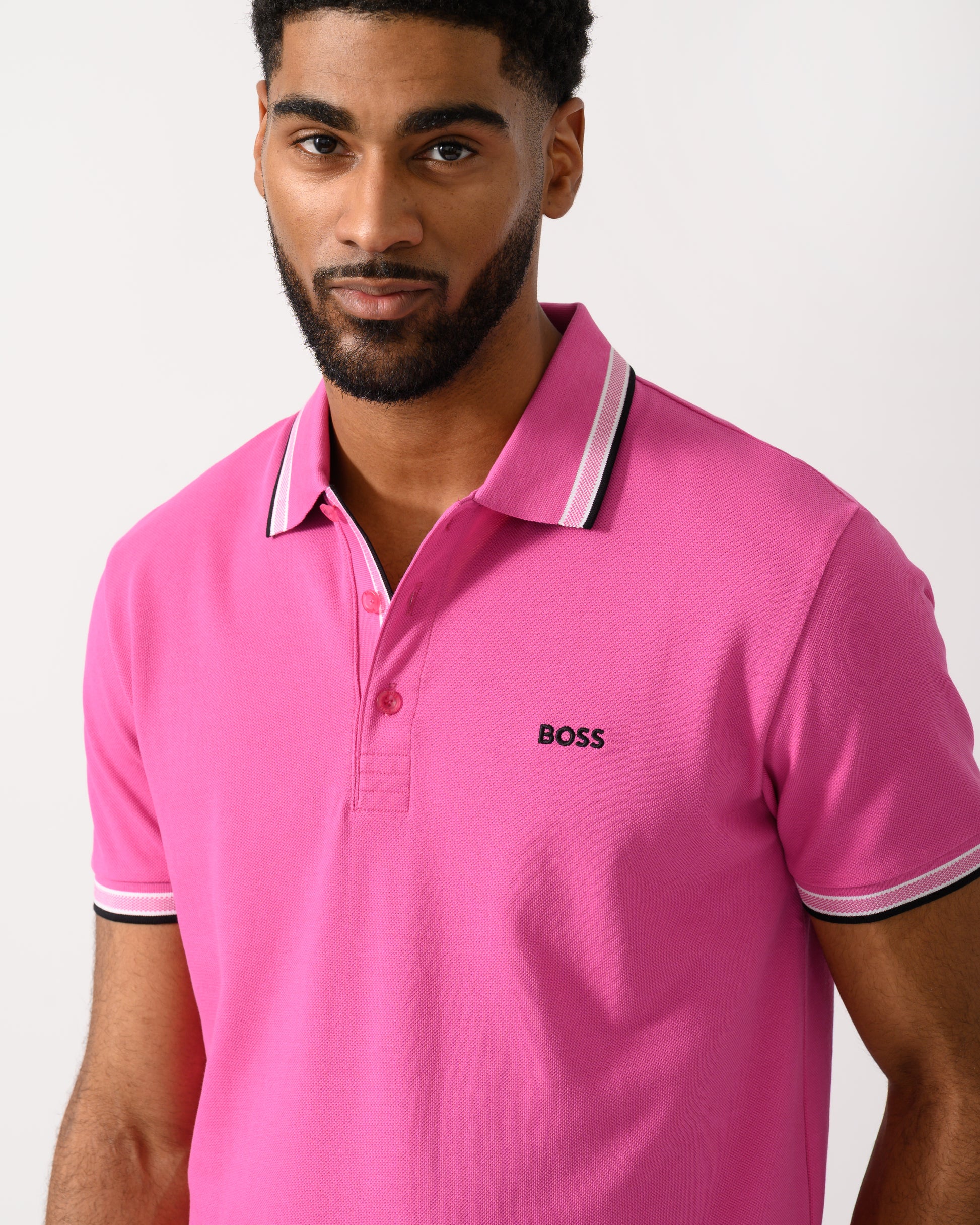 detail shot of a model wearing a BOSS Green Paddy Mens Cotton-Piqué Polo Shirt with Contrast Logo in Bright Pink