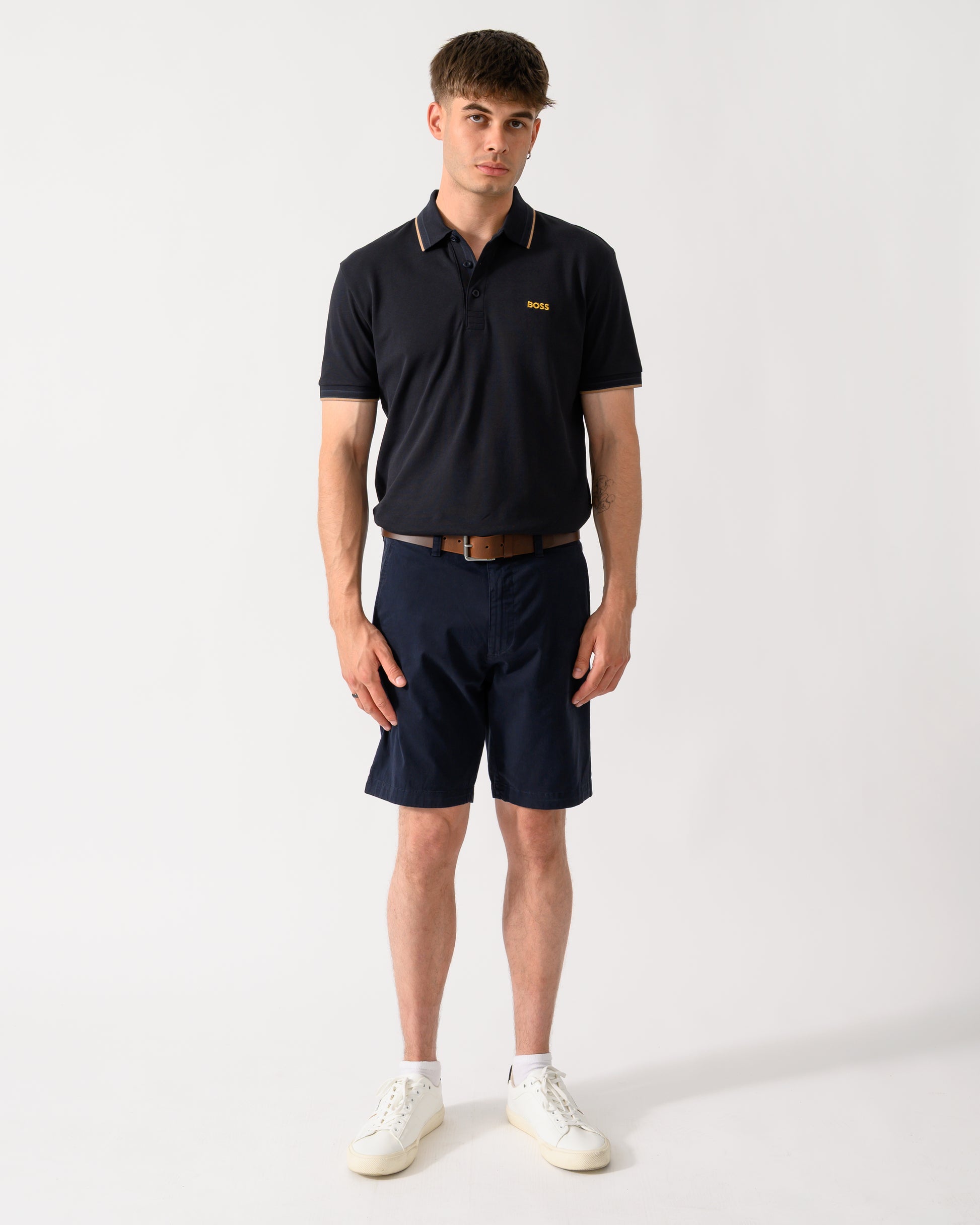 full length shot of a model wearing a BOSS Green Paddy Mens Cotton-Piqué Polo Shirt with Contrast Logo in Dark Blue 401