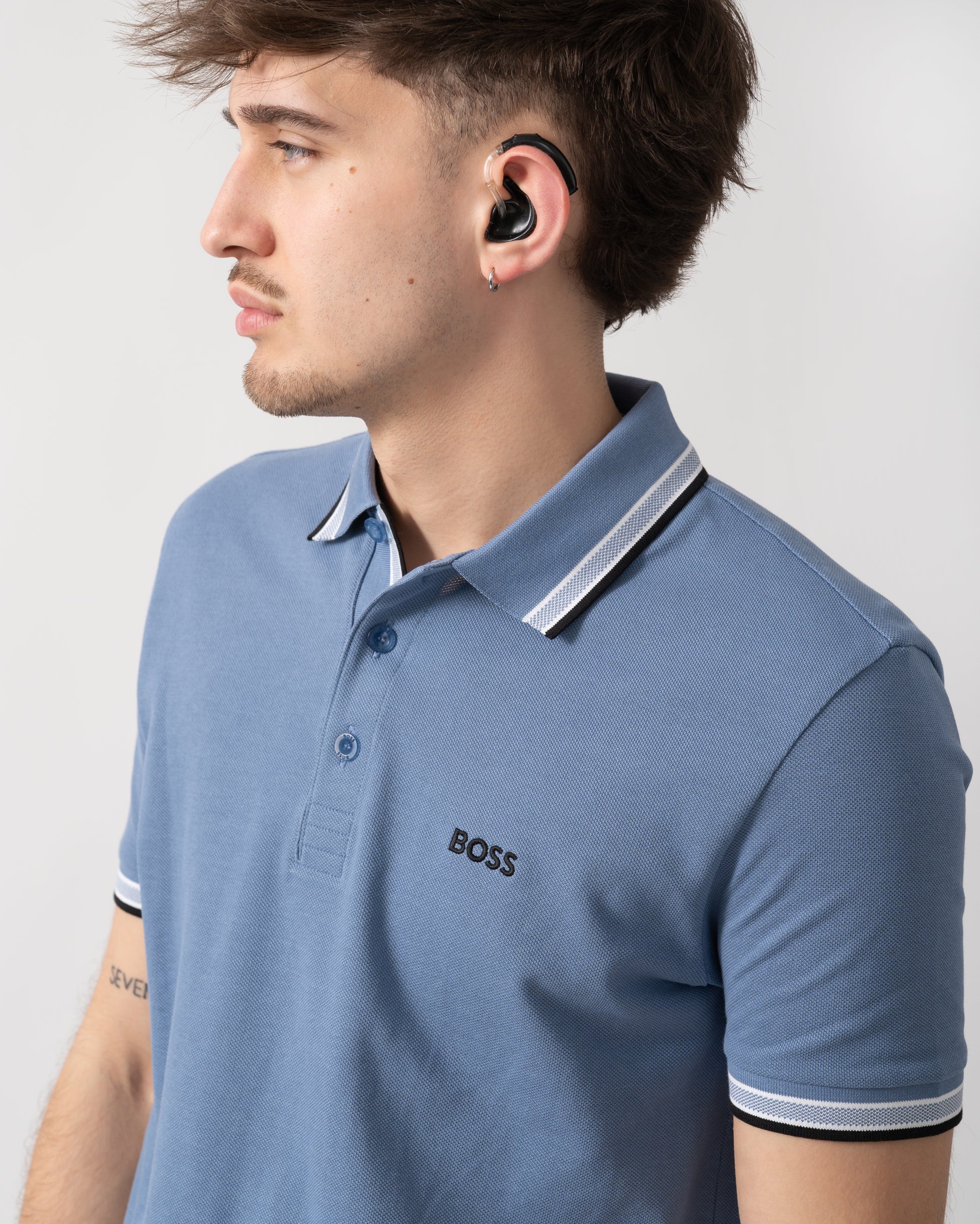 close up shot of a model wearing a BOSS Green Paddy Mens Cotton-Piqué Polo Shirt with Contrast Logo in Open Blue 462