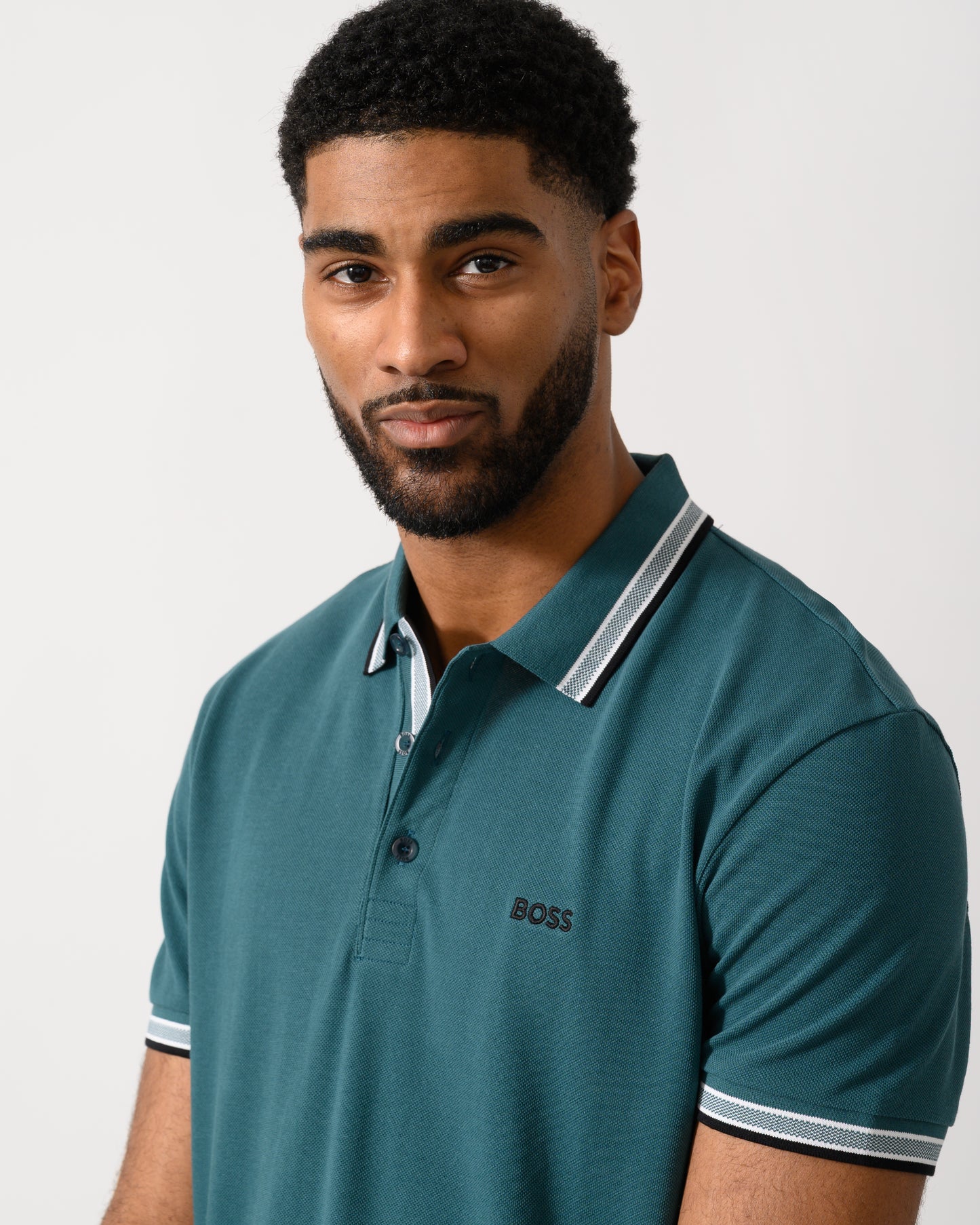 detail shot of a model wearing a BOSS Green Paddy Mens Cotton-Piqué Polo Shirt with Contrast Logo in Open Green