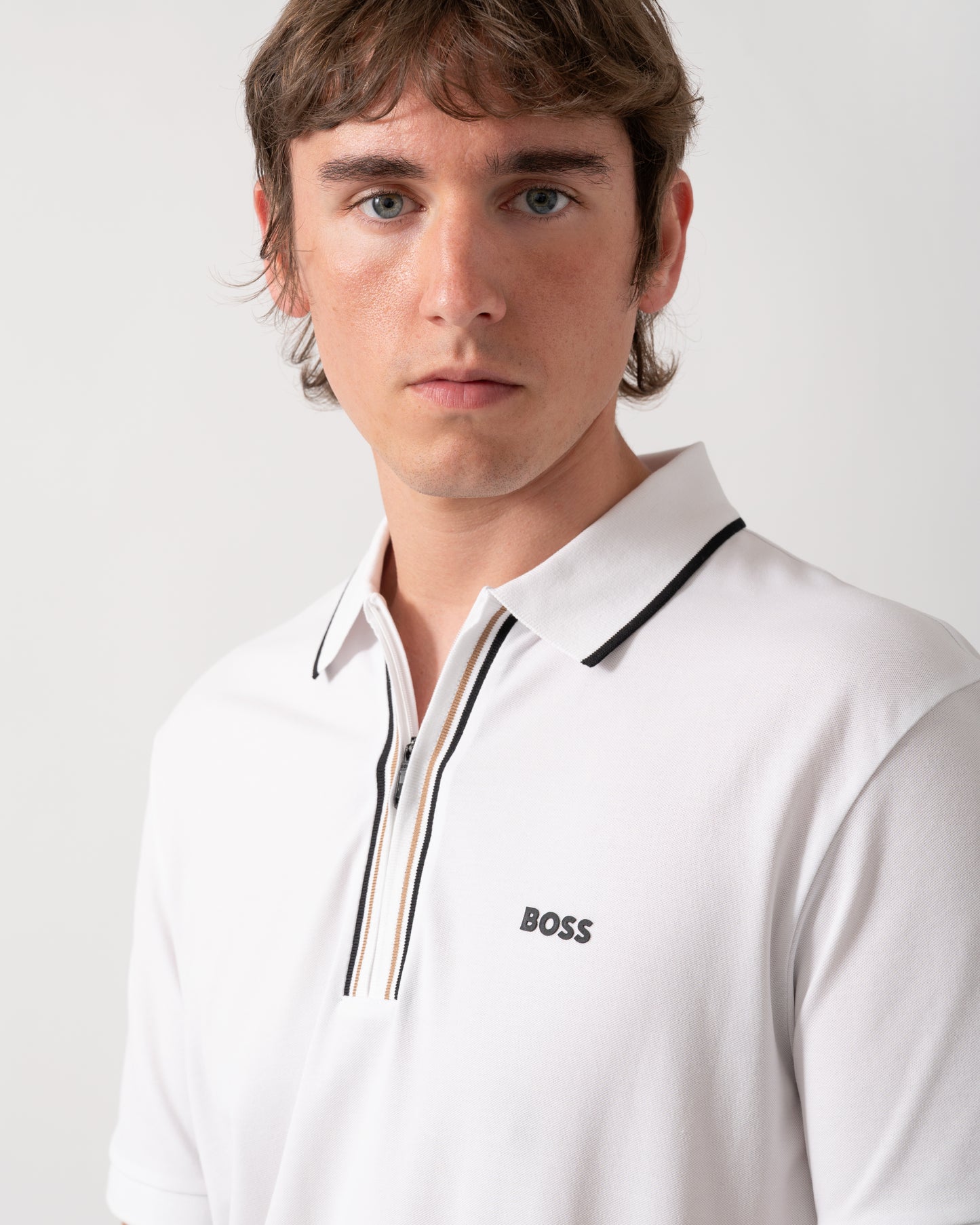 close up of a model wearing a BOSS Green Philix Mens Slim Fit Zip Polo Shirt in Moisture-Wicking Stretch Cotton White 100