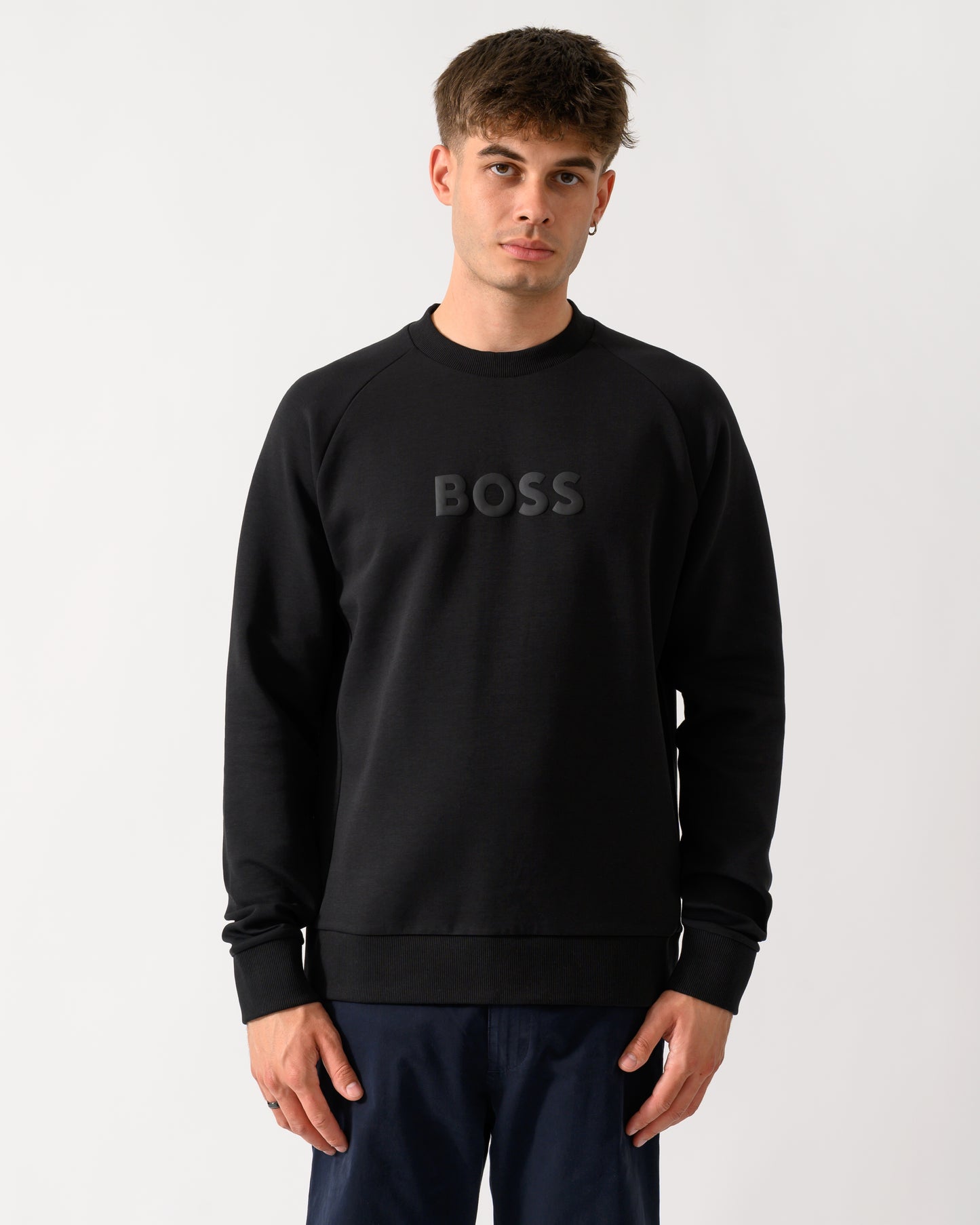 model wearing a BOSS Green Salbo Mens Crew Neck Sweatshirt with Tonal Logo in Black 001