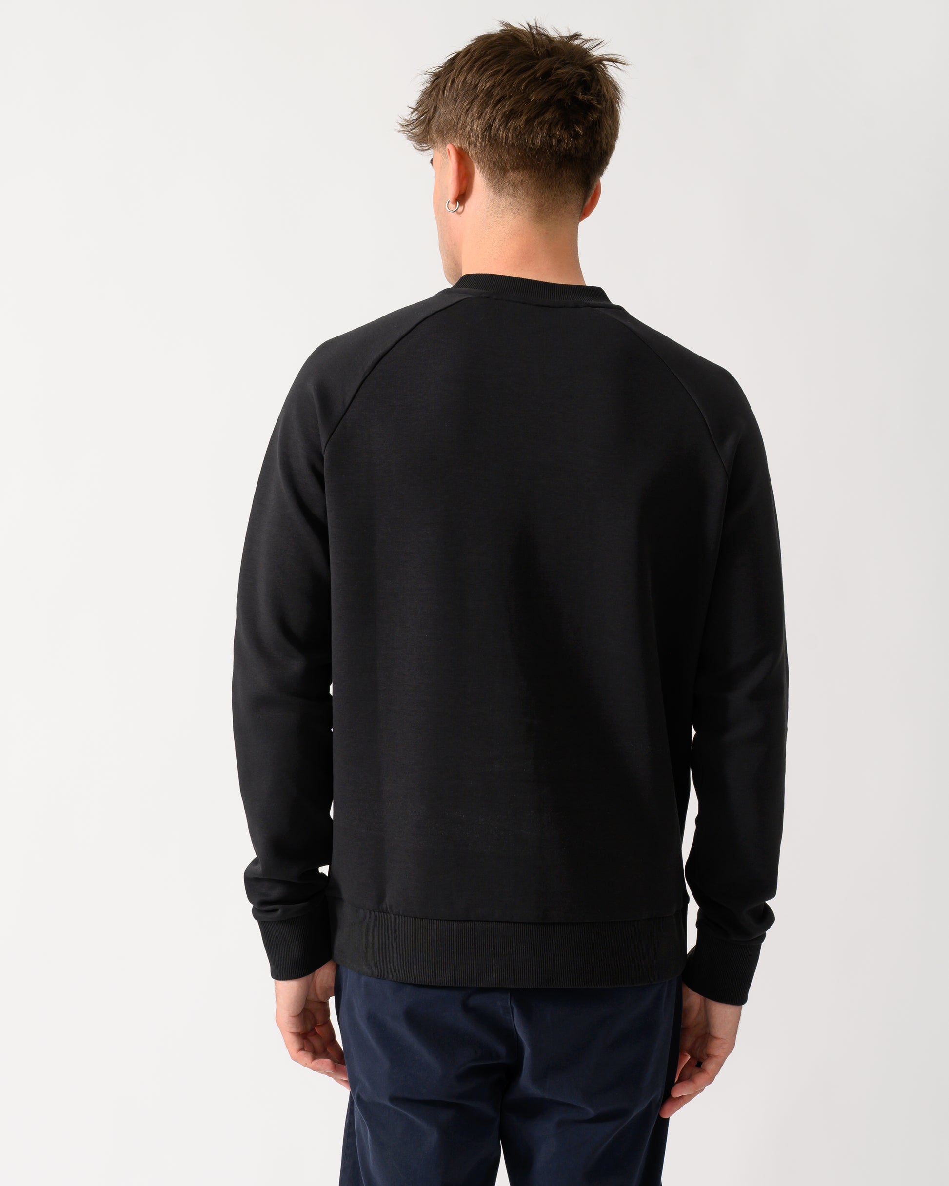 back shot of a model wearing a BOSS Green Salbo Mens Crew Neck Sweatshirt with Tonal Logo in Black 001