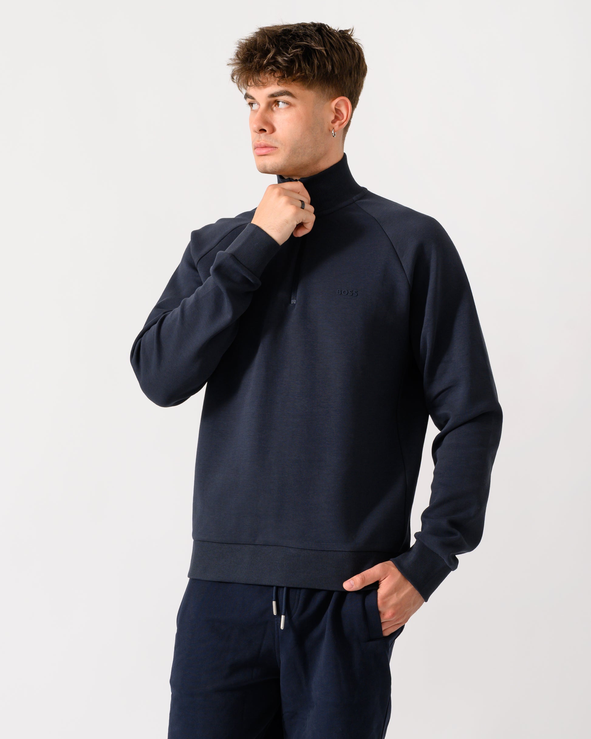 model wearing a BOSS Green Sweat Mens quarter Zip Sweatshirt in Dark Blue 402