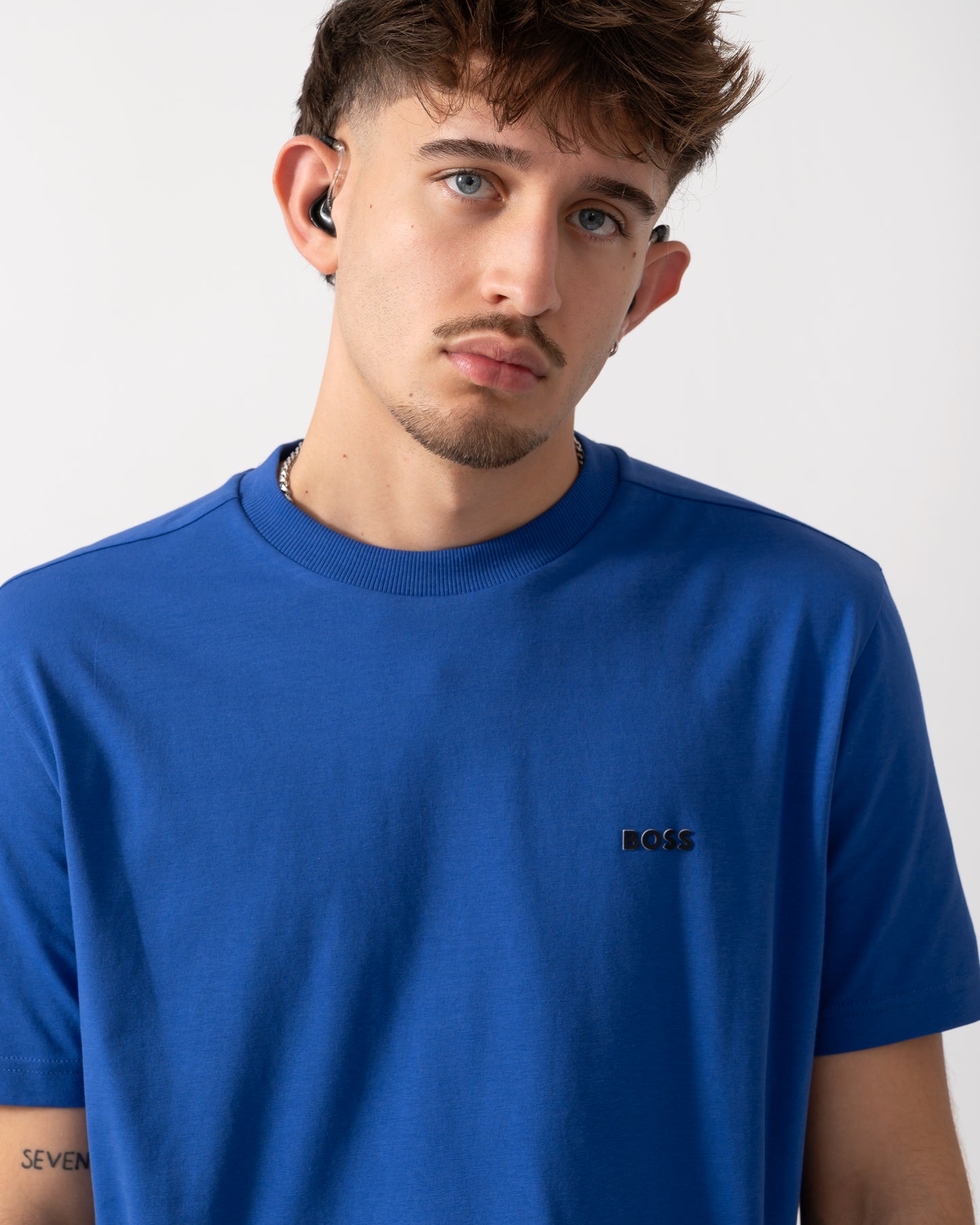 Close up shot of a Model wearing a BOSS Green Tee Mens Stretch Cotton T-Shirt with Contrast Logo in Medium Blue