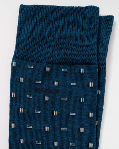 A pair of folded dark teal blue BOSS knit socks with a small geometric pattern of white and beige stripes, shown on a clean white background.