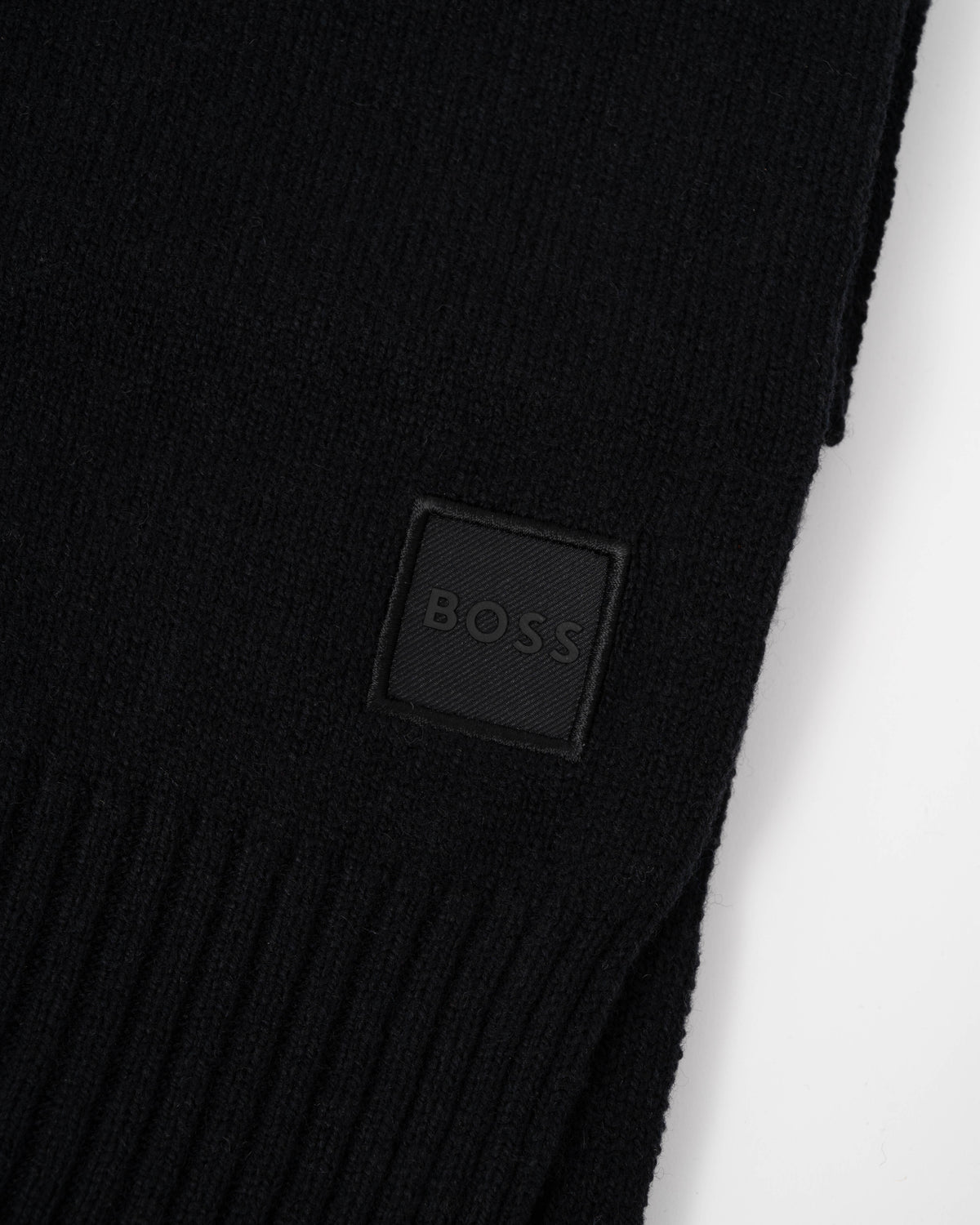 Close up of the logo of BOSS Orange Akaio R Mens plain-knit scarf with woven logo badge - Black 001