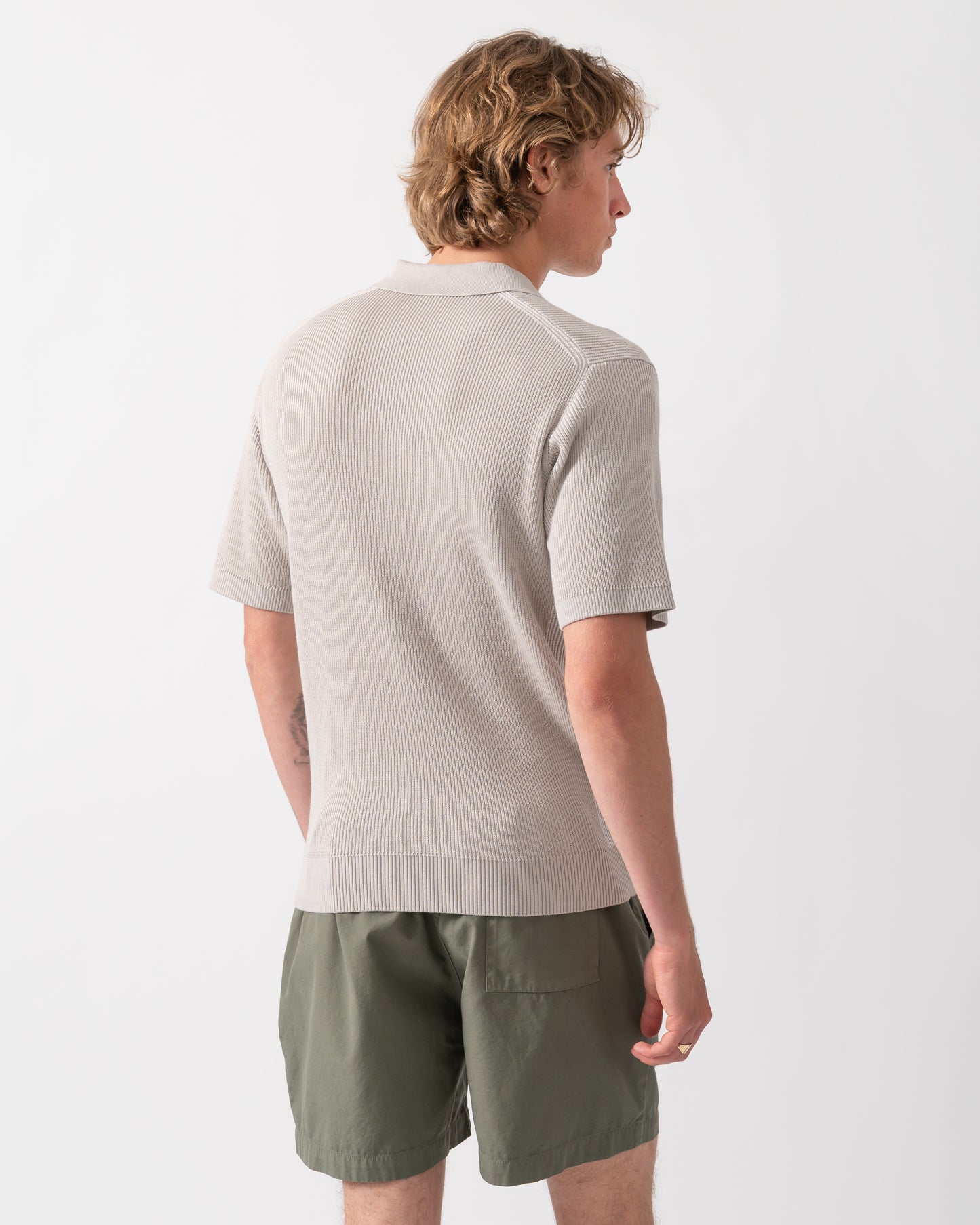 back shot of a Model wearing a BOSS Orange Aravolo Mens Short Sleeve Knit Polo Shirt in Open Grey 070