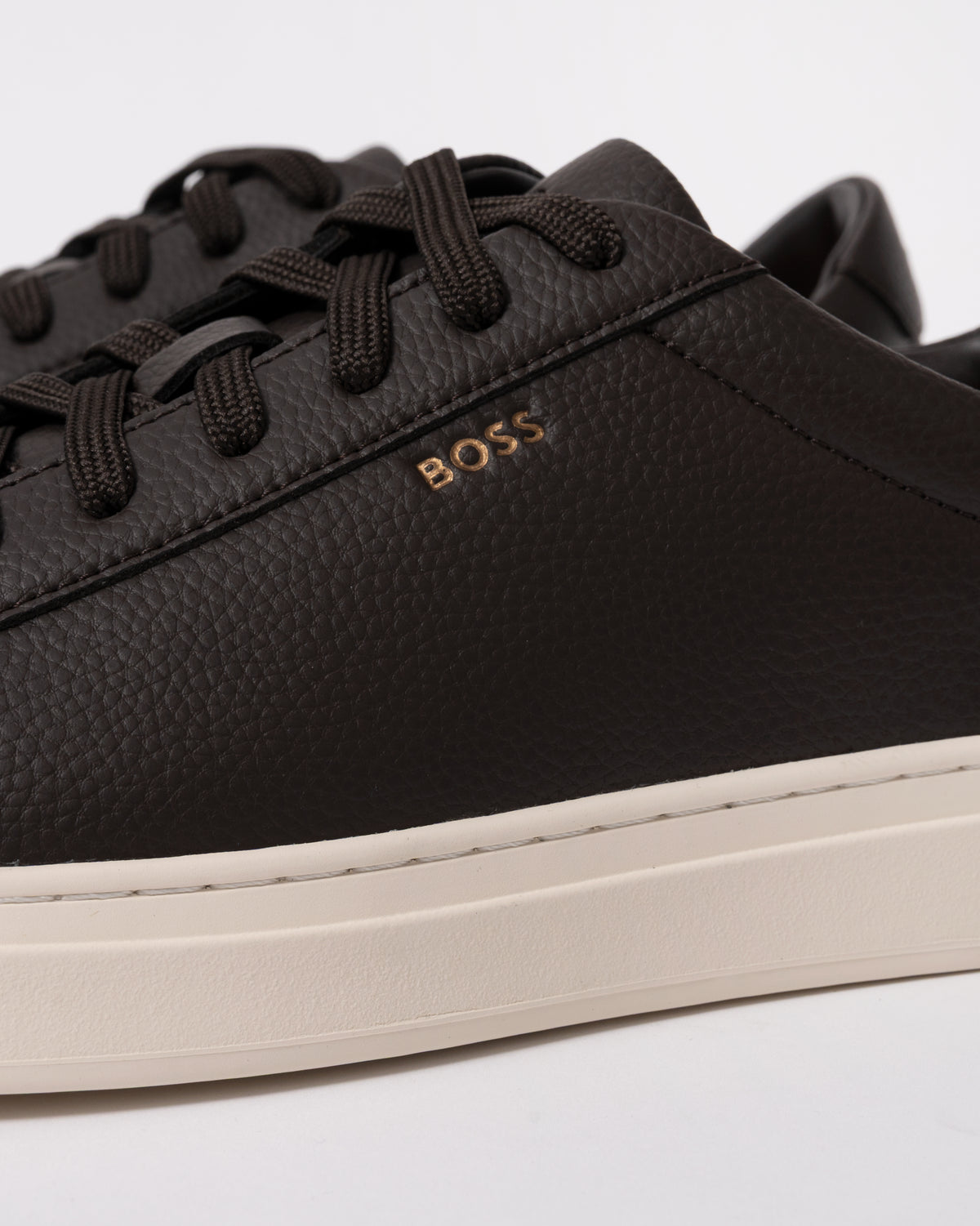 Studio photograph showing close up of BOSS Orange Kieran Mens Grained-leather trainers with rubber sole in Dark Brown 203
