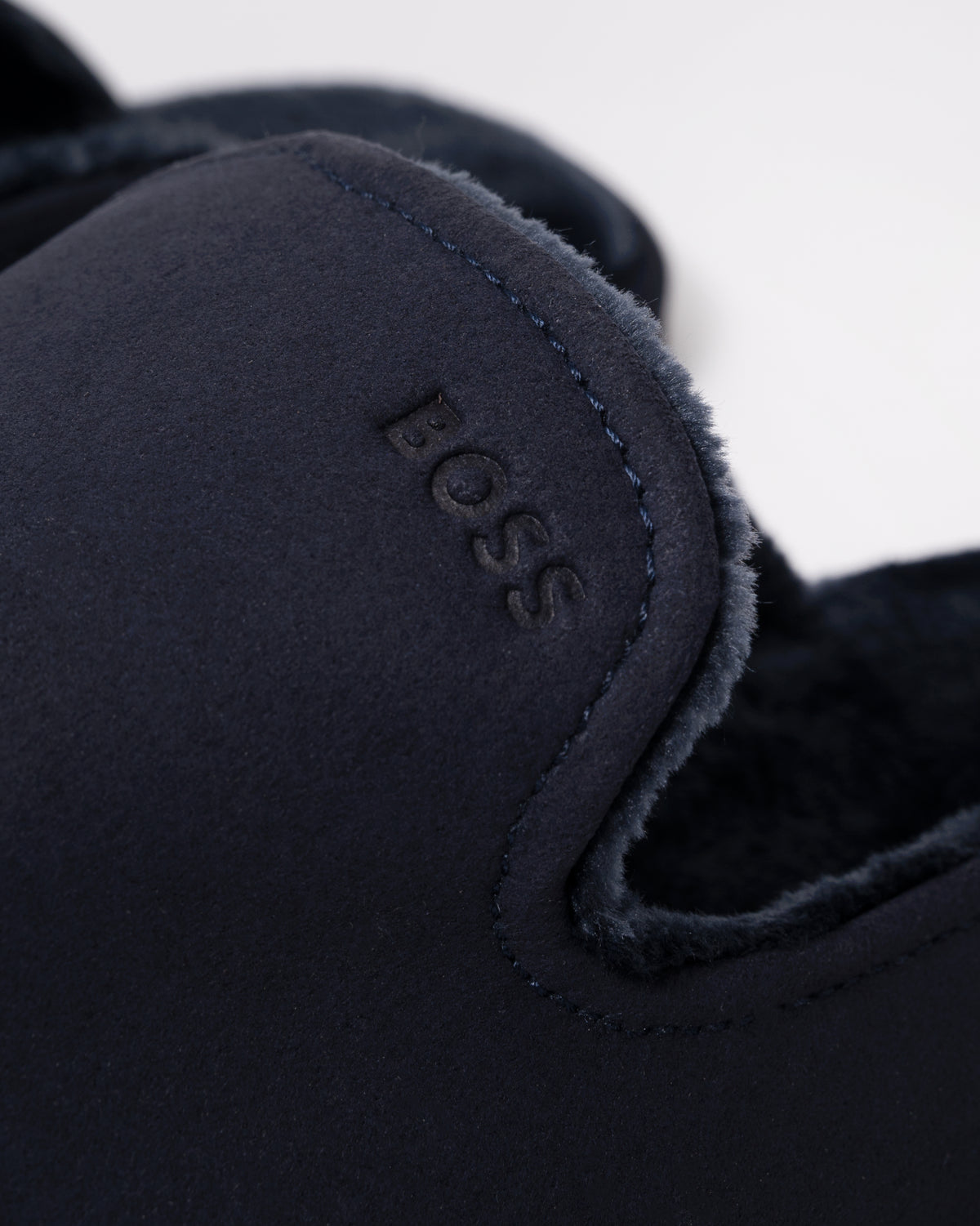 close up Studio photograph of BOSS Orange Mens Shearling-lined slip-on slippers with logo detail in Dark Blue 404