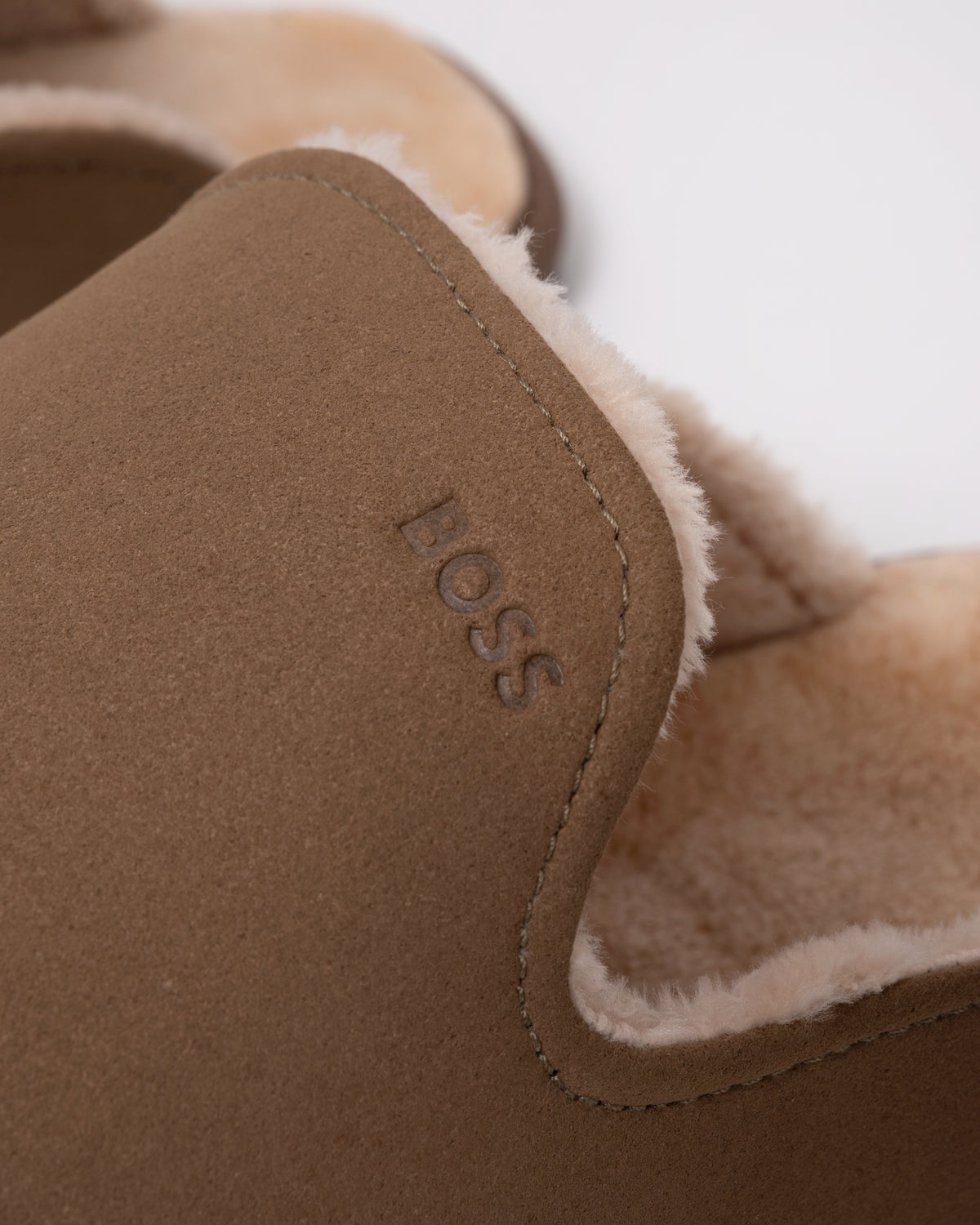 Studio photograph showing close up of BOSS Orange Mens Shearling-lined slip-on slippers with logo detail in Medium Beige 260
