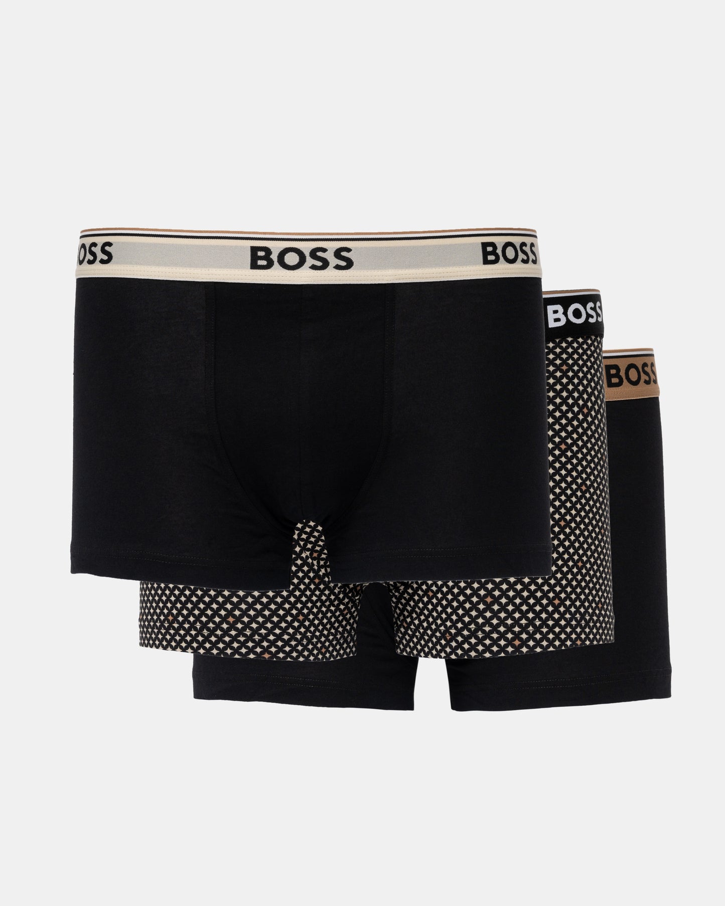 Three BOSS men's boxer briefs in black, arranged in a 3-pack. The front pair has a beige waistband with black BOSS lettering, while the pairs behind it feature black and white polka-dot patterns on the legs and a brown BOSS logo on their waistbands.