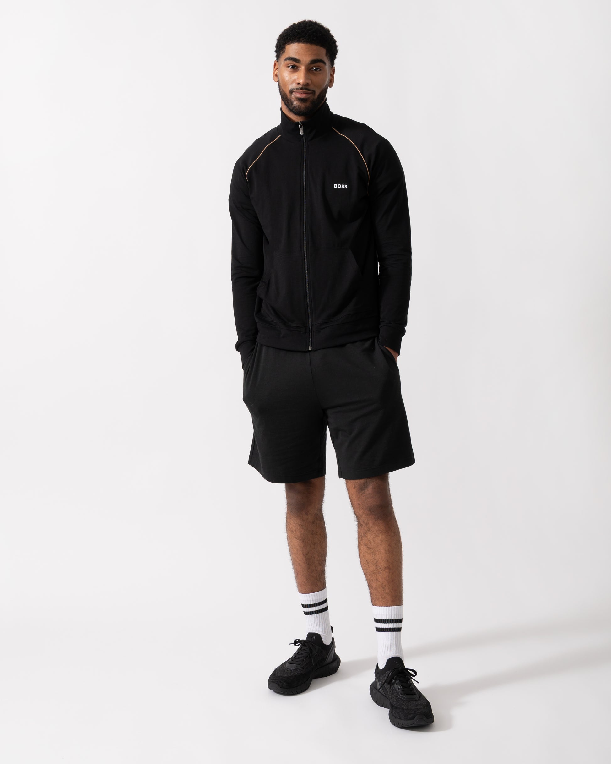 Full length shot of a Model wearing a BOSS Orange Mix&Match Mens Logo-Embroidered Full Zip Loungewear Jacket in black Stretch-Cotton Jersey