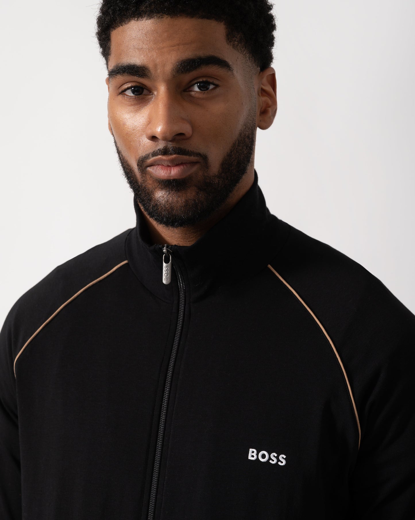 Close up shot of a Model wearing a BOSS Orange Mix&Match Mens Logo-Embroidered Full Zip Loungewear Jacket in black Stretch-Cotton Jersey