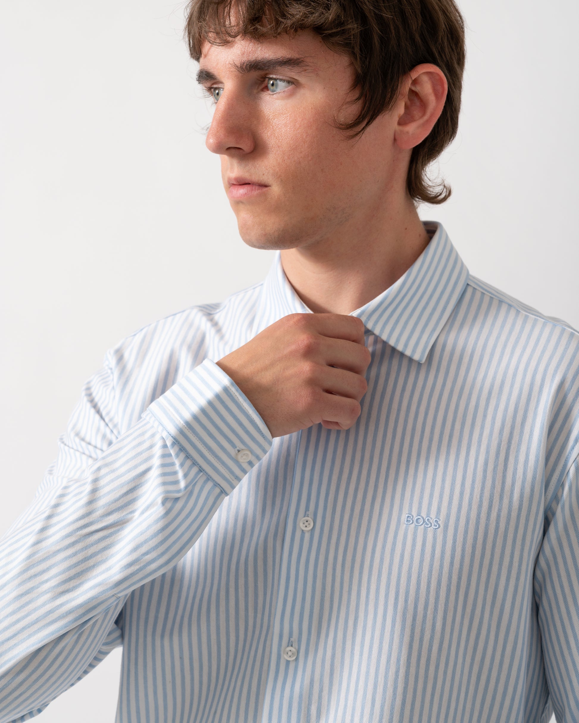 close up of a model wearing a BOSS Orange Mysoft Mens Slim-Fit Shirt in Melange Cotton Jersey in Open Blue 461